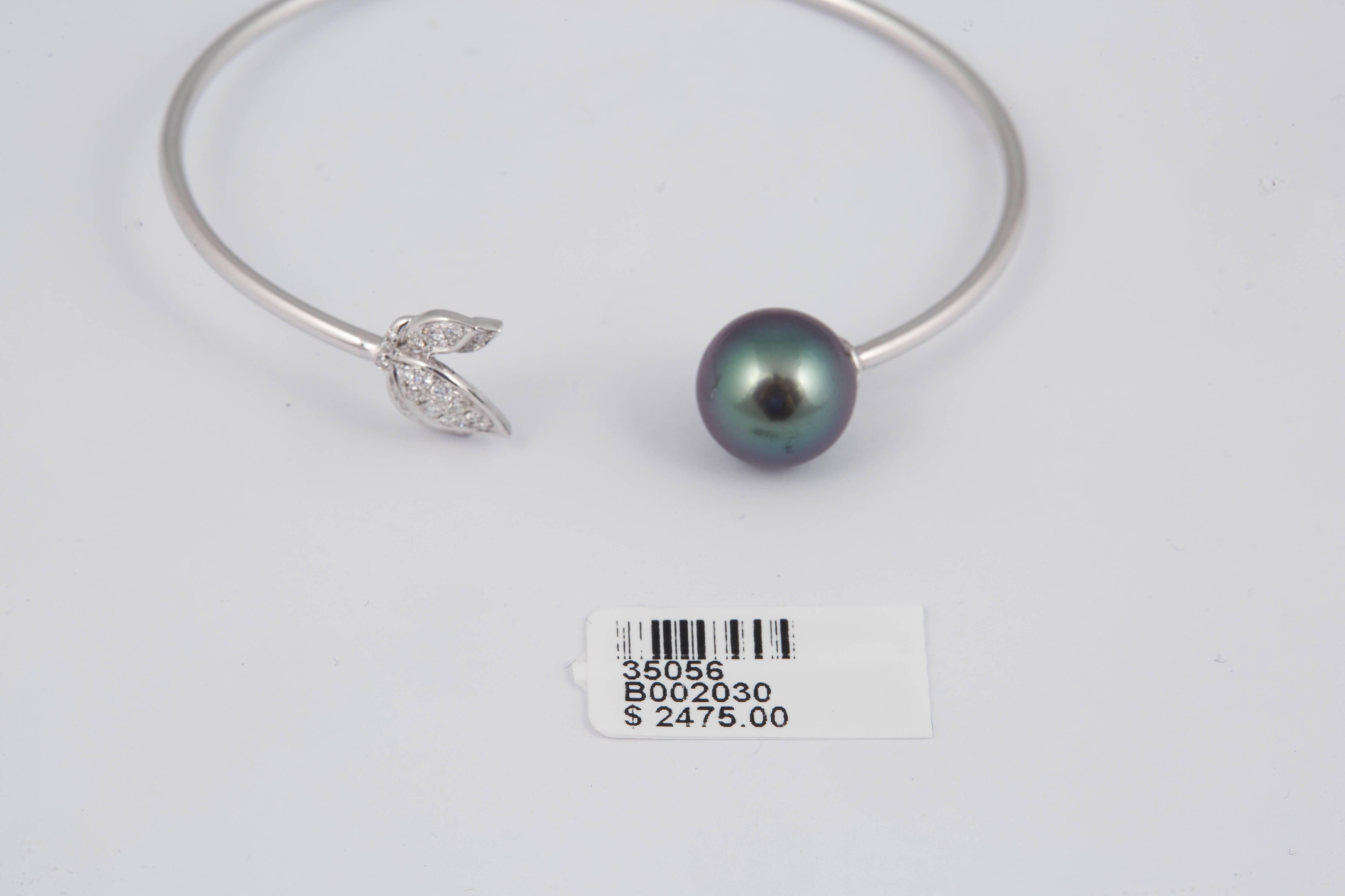 18K White Gold bangle bracelet featuring 23 round brilliants weighing 0.22 Carats and one Tahitian Pearl measuring 11-12 mm.