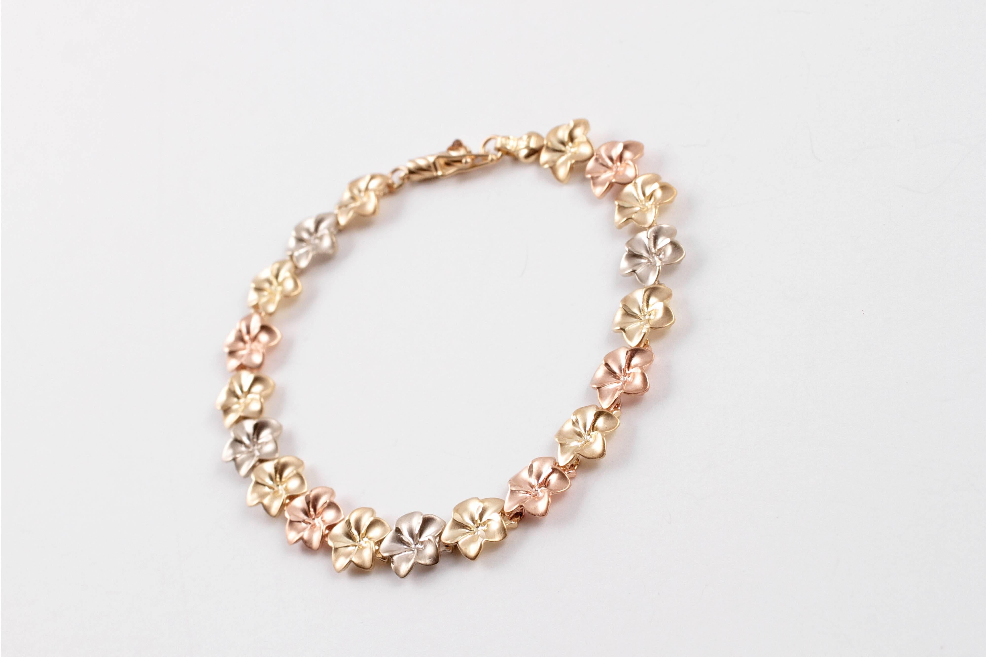 This sweet tri-color bracelet measures 7 inch in length and supports nineteen delightful yellow, white, and rose gold flowers.  All in 14 karat.
