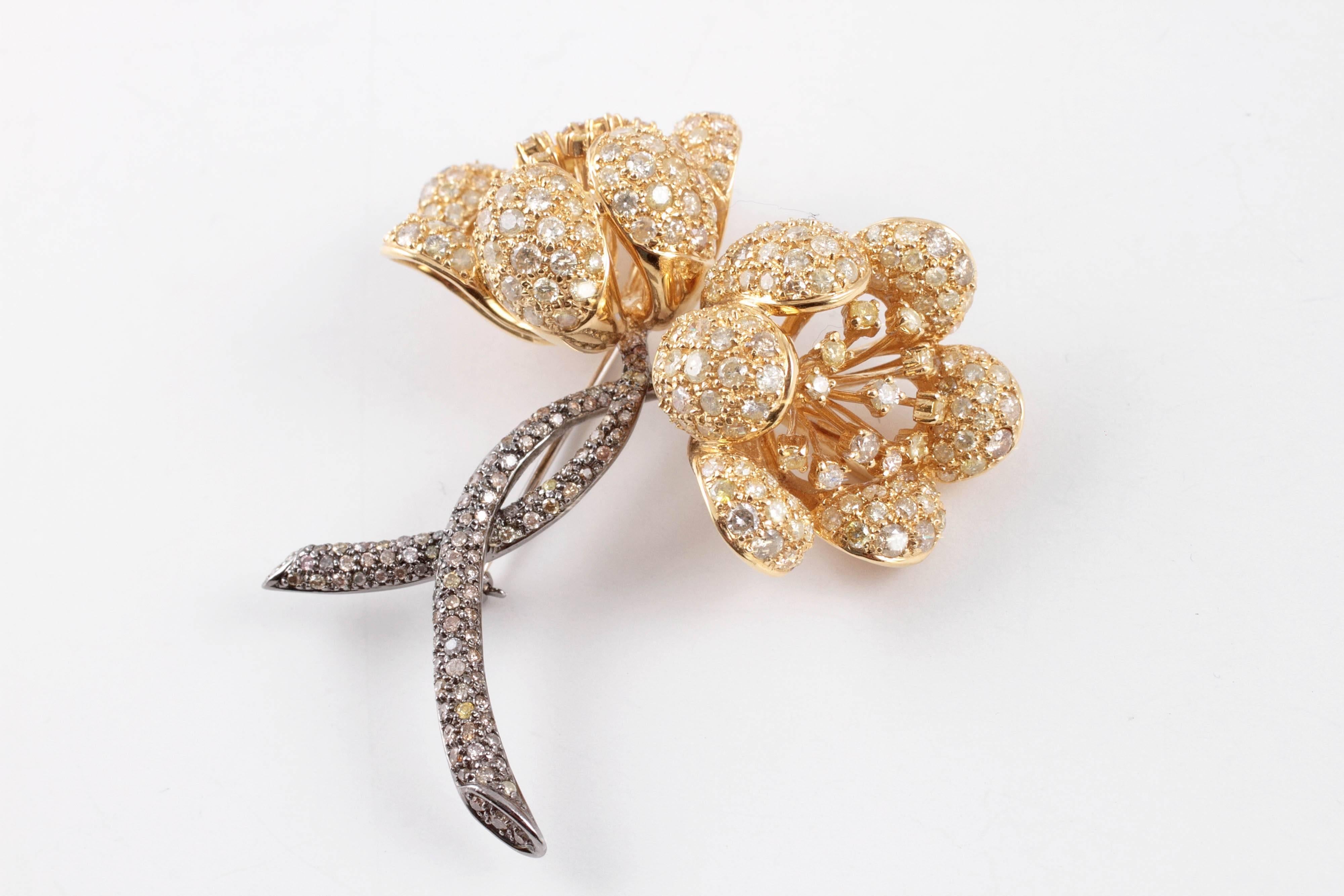 14.80 carats of white, yellow and brown diamonds adorn this lovely flower brooch!  It is composed of 18 karat yellow and white gold and is secured with a straight-pin clasp.