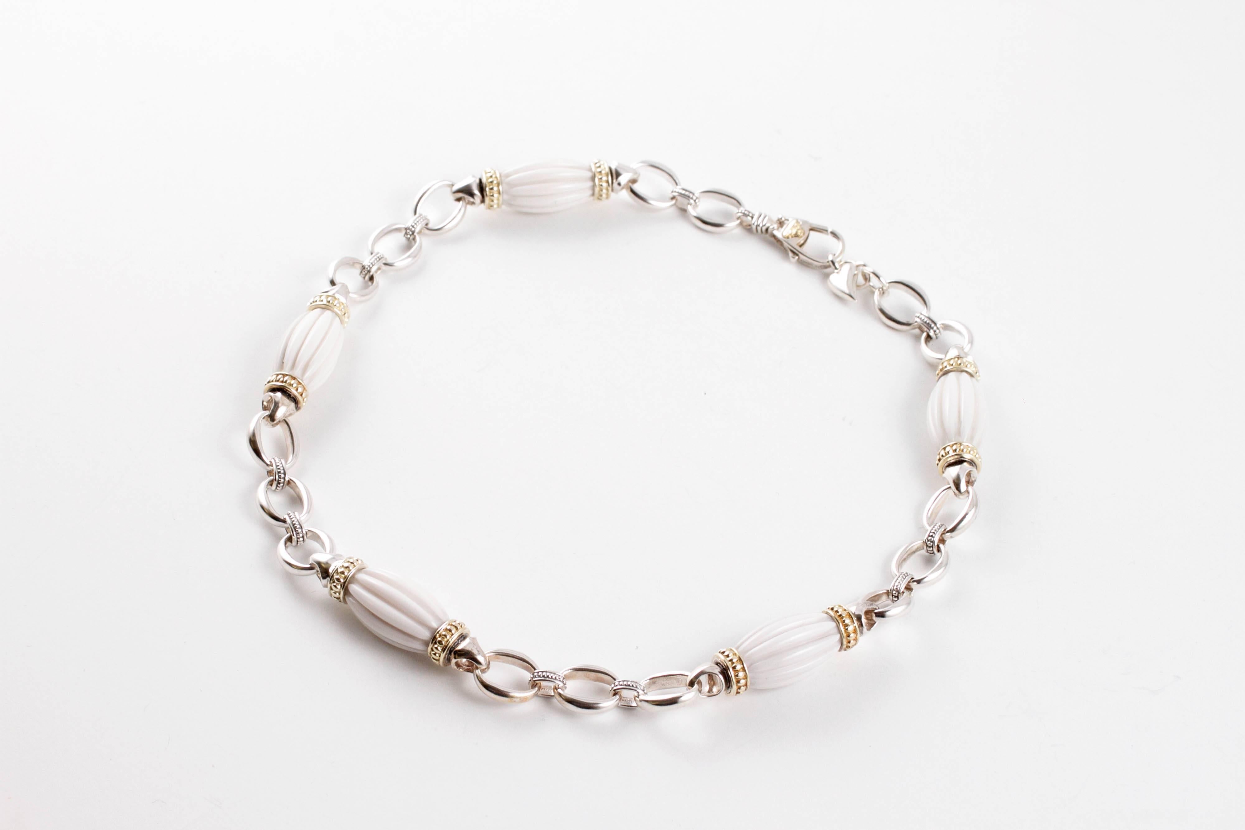 Composed of 18 karat yellow gold and sterling silver, this fun necklace supports five fluted ceramic beads.