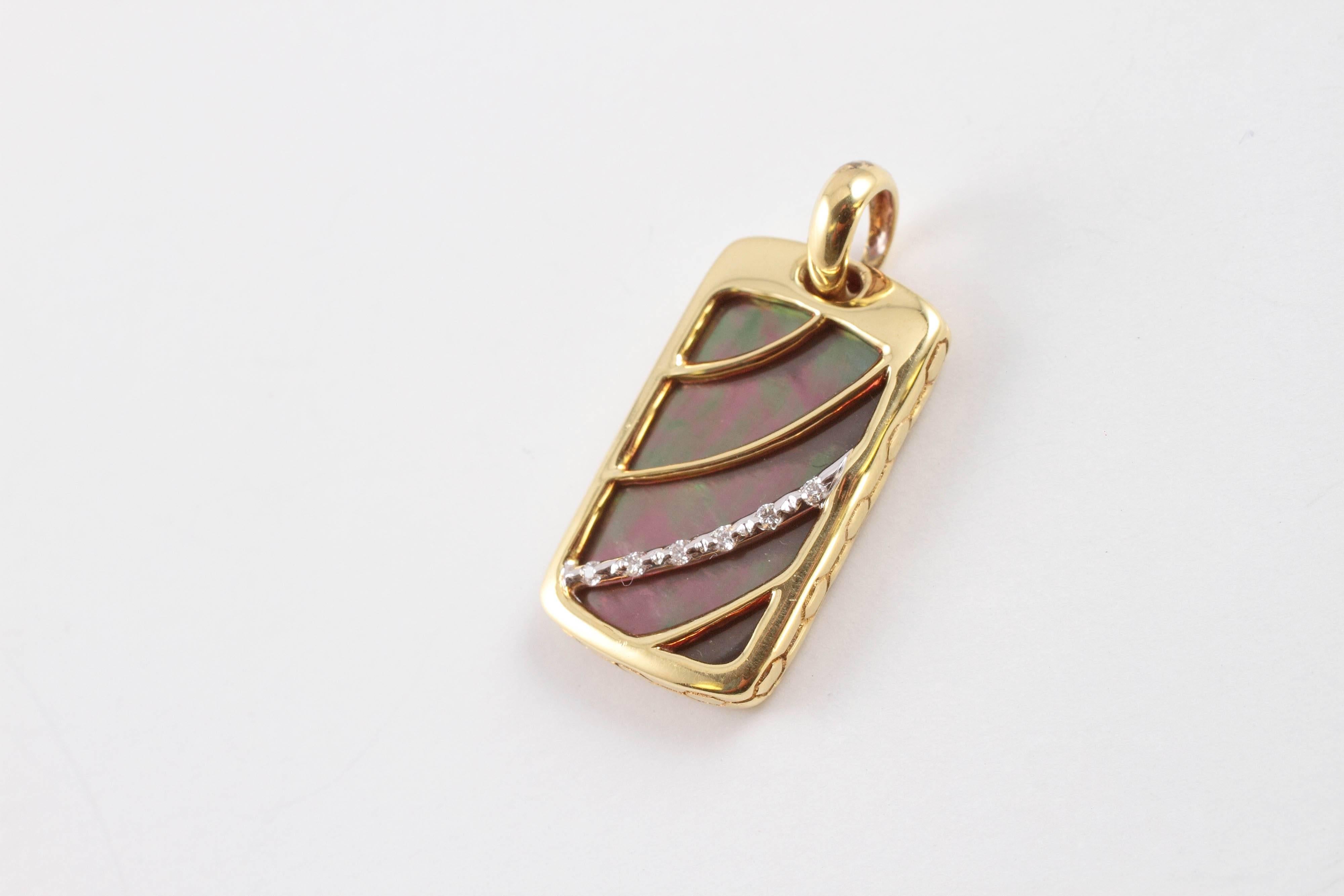 This yellow gold, mother-of-pearl and diamond pendant by Asch/Grossbardt is suspending from a 16 1/2 inch yellow gold chain. 