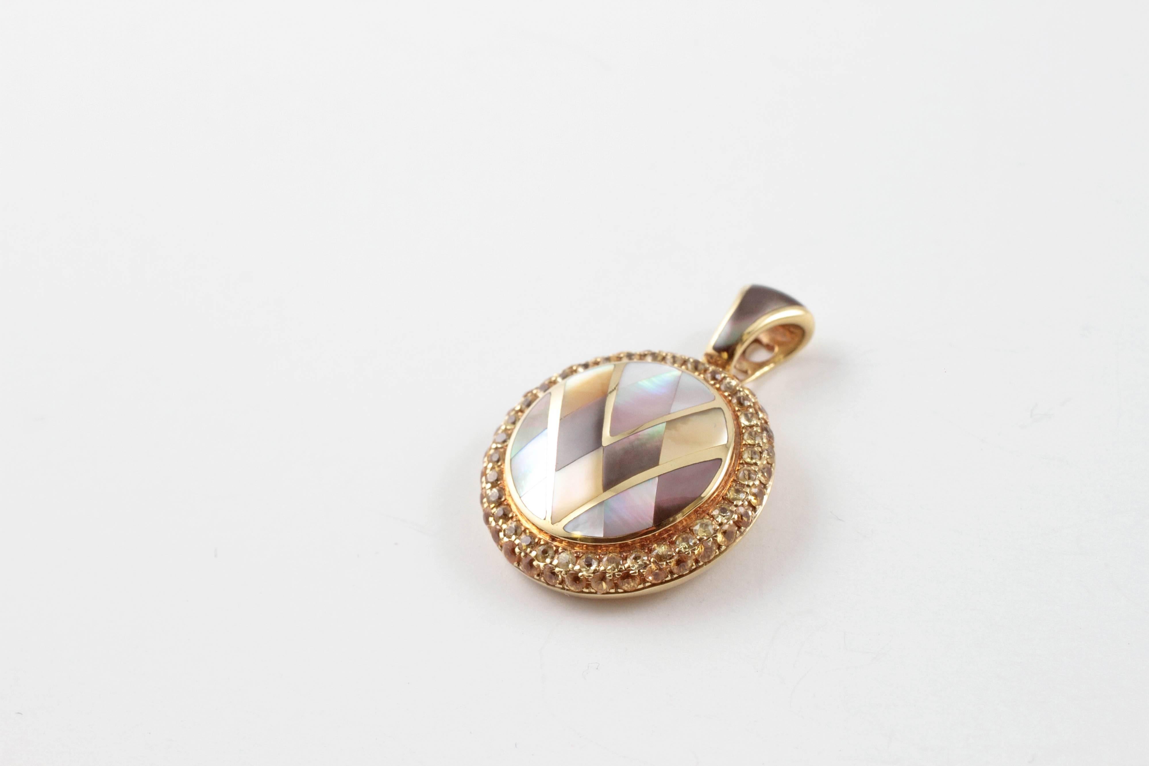 A lovely 14 karat yellow gold, yellow sapphire and mother of pearl inlaid pendant by Asch Grossbardt!