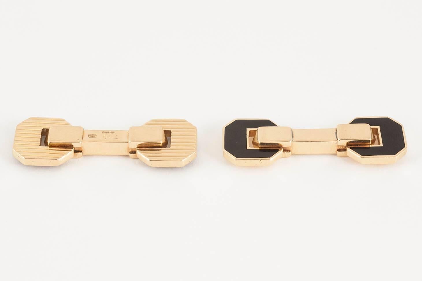 A pair of 750 marked [18kt] gold cufflinks of day and night design,one side with fluted lines,the other in black enamel,hinged ,of heavy quality ,signed HW for Harry Winston,c,1980