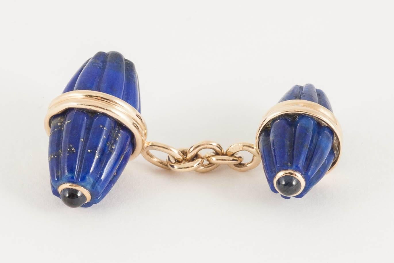 A Vintage pair of melon shaped, fluted, lapis lazuli, double sided cufflinks of two sizes, each terminal set with a cabochon sapphire and mounted in 18 karat yellow gold.
Larger lapis lazuli link measures 20mm in height x 10mm in width.
1960's