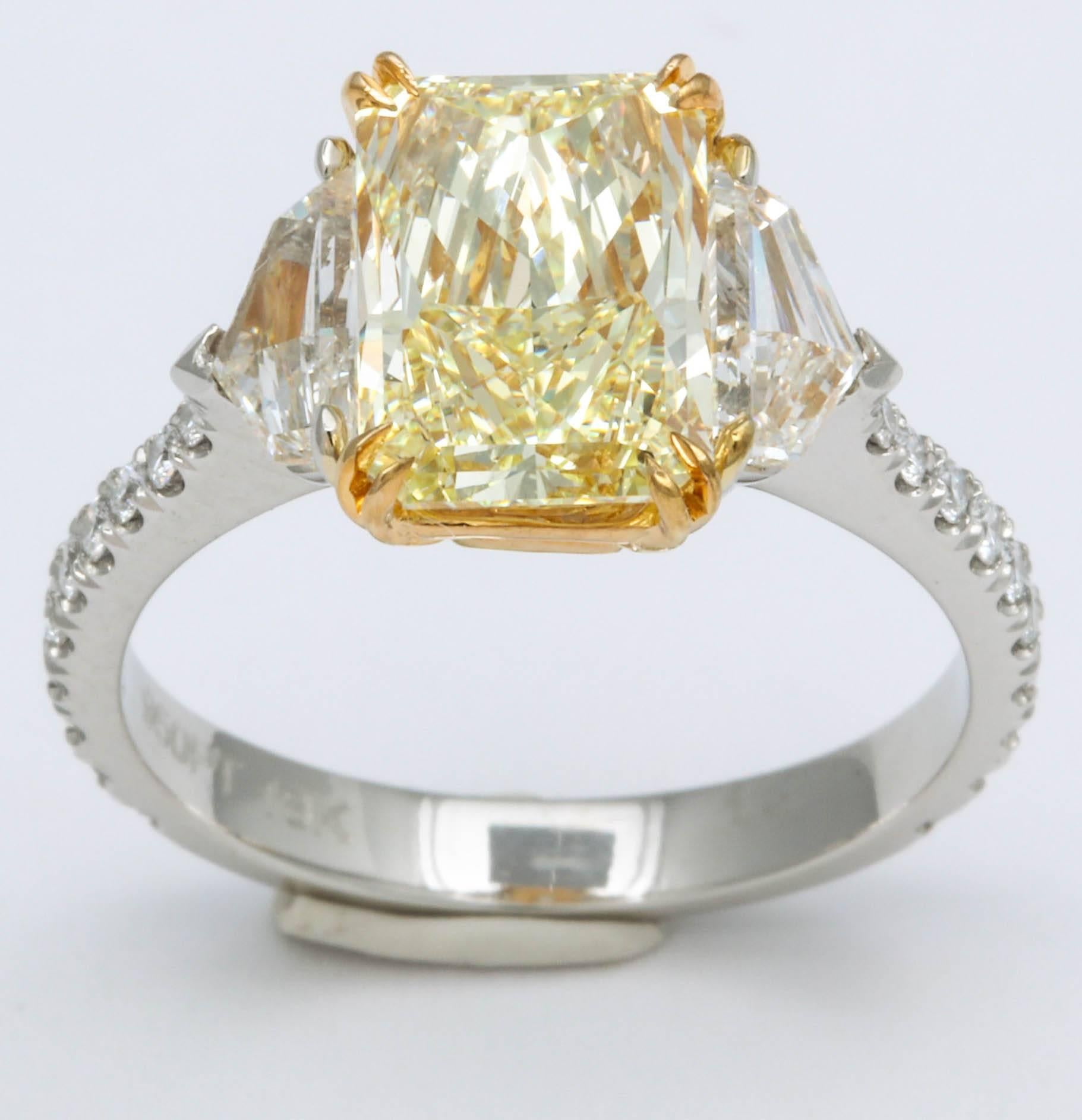 
A beautiful yellow diamond set in a unique custom mounting. 

2.34 carat Fancy Yellow radiant cut center diamond -- the diamond has a spectacular cut to maximize brilliance and size,  it looks like a 3 carat stone!!

The stone is VS1 clarity,