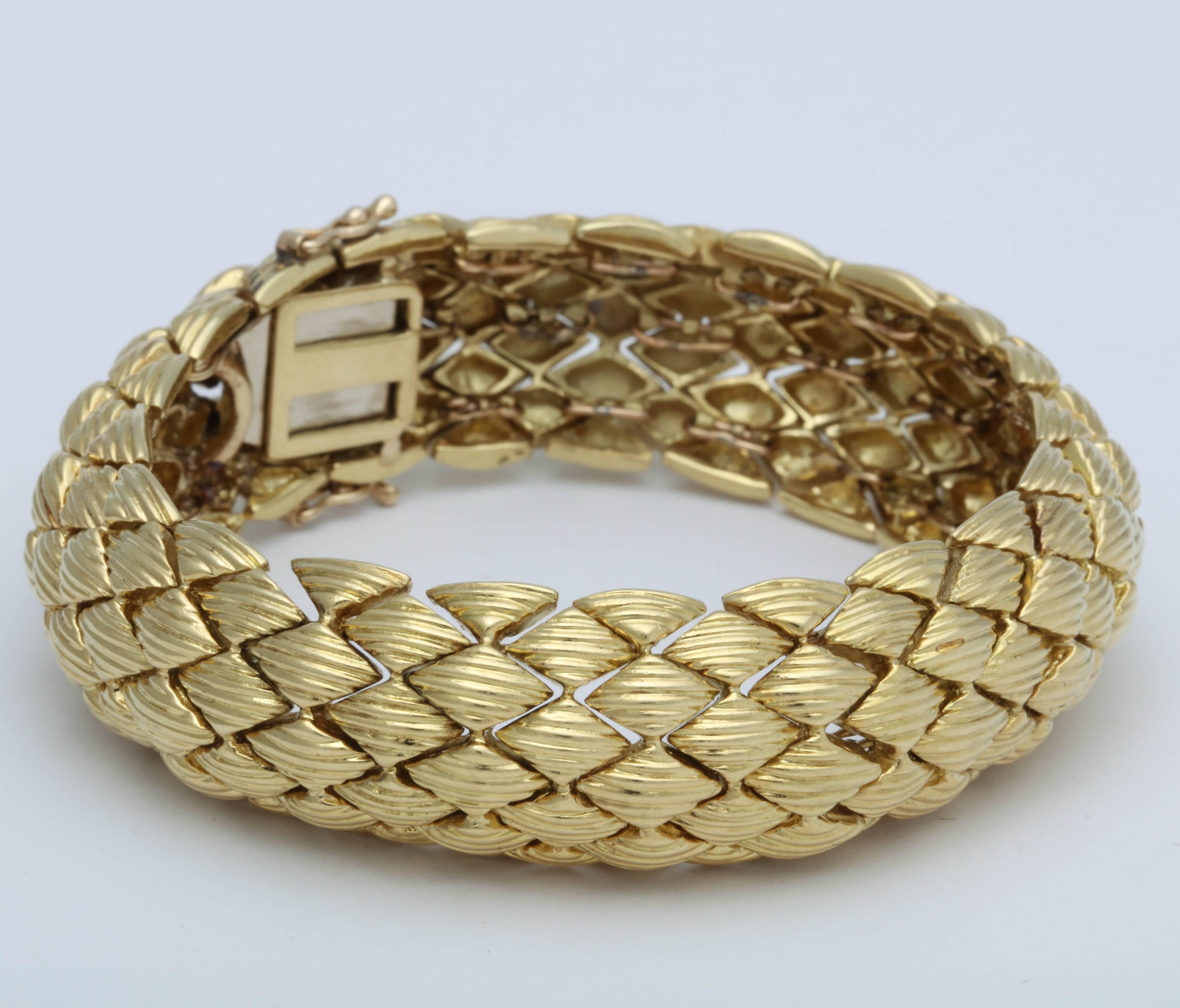 bracelet en or jaune 18 carats avec une forme flexible de voûte en forme de tonneau.  Possède une sécurité à 2 chiffres en 8.  Très luxueux. 