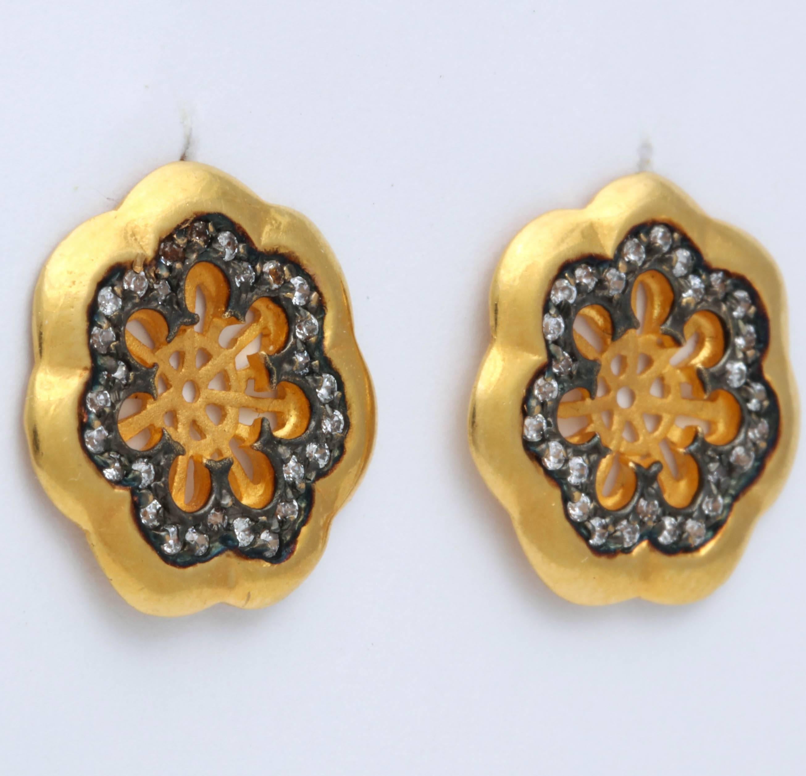 These are 22 kt plus gold earrings. The single cut diamonds are about .84 cts and are set in oxidized silver. The contrast between the bright yellow gold and dark silver is striking.The center is a delicately cut out flower center and is  in a matte
