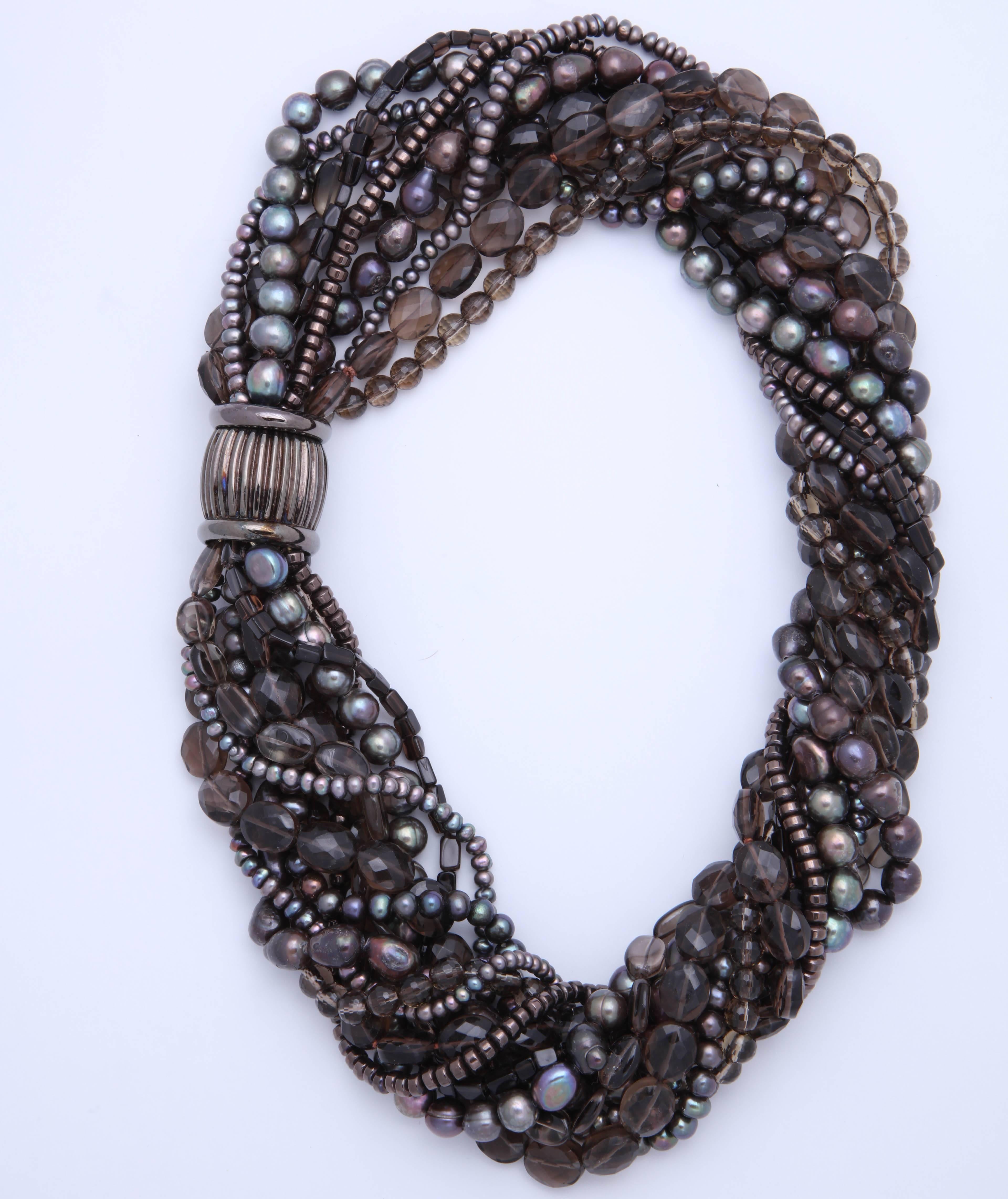 This spectacular necklace is 21 in. untwisted and 20 in. twisted, thus the name 'torsade.'
It consists of a total of 11 strands of smoky quartz, faceted and smooth,  brown fresh water pearls of different sizes and hematite rondells. The clasp is