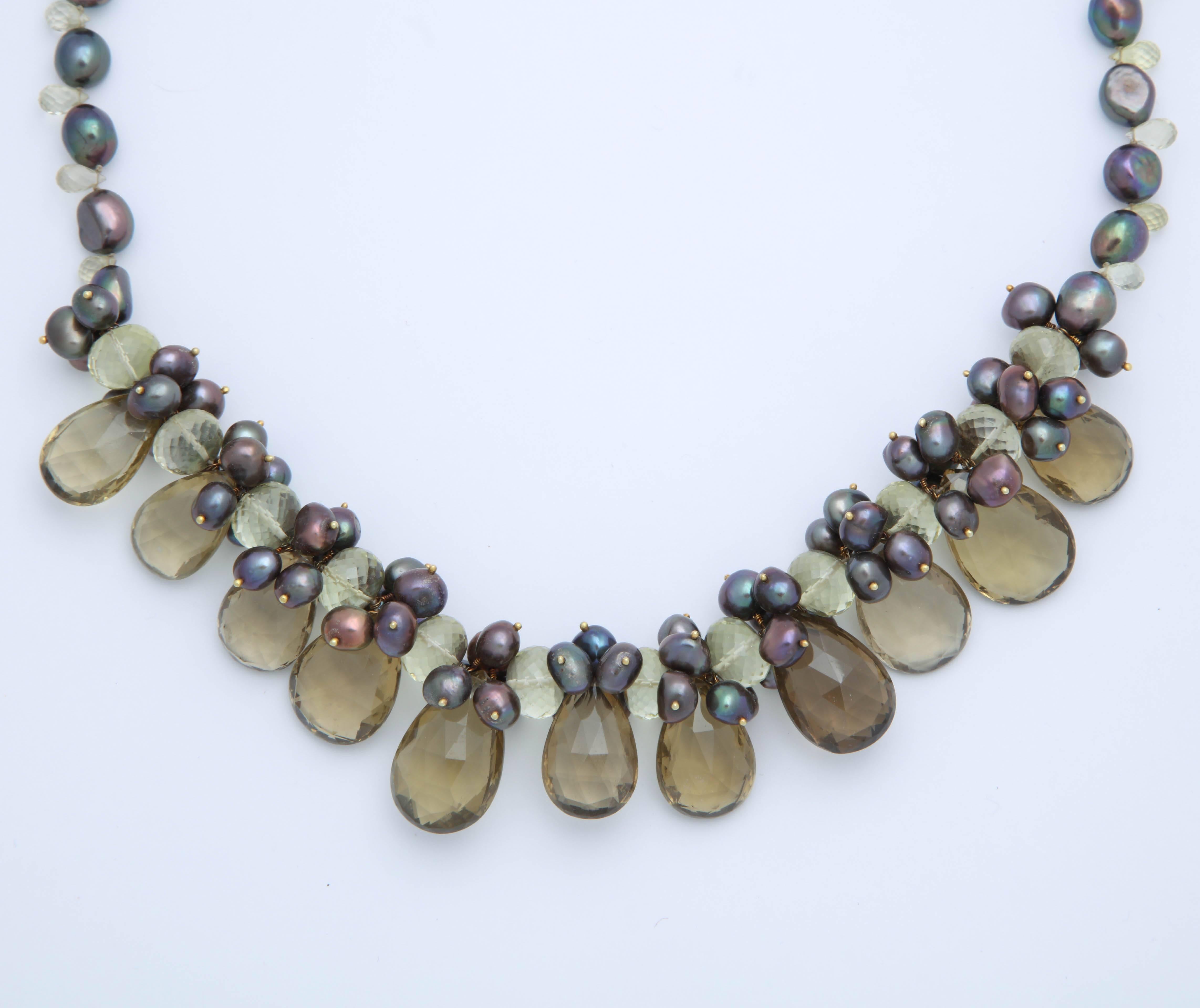 This striking necklace has 11 large lemon quartz pear shaped briolettes.  In between the briolettes are micro faceted lemon quartz beads and brownish-green fresh water pearls on 18 kt gold wires. The total length of this gorgeous necklace is 22 in.