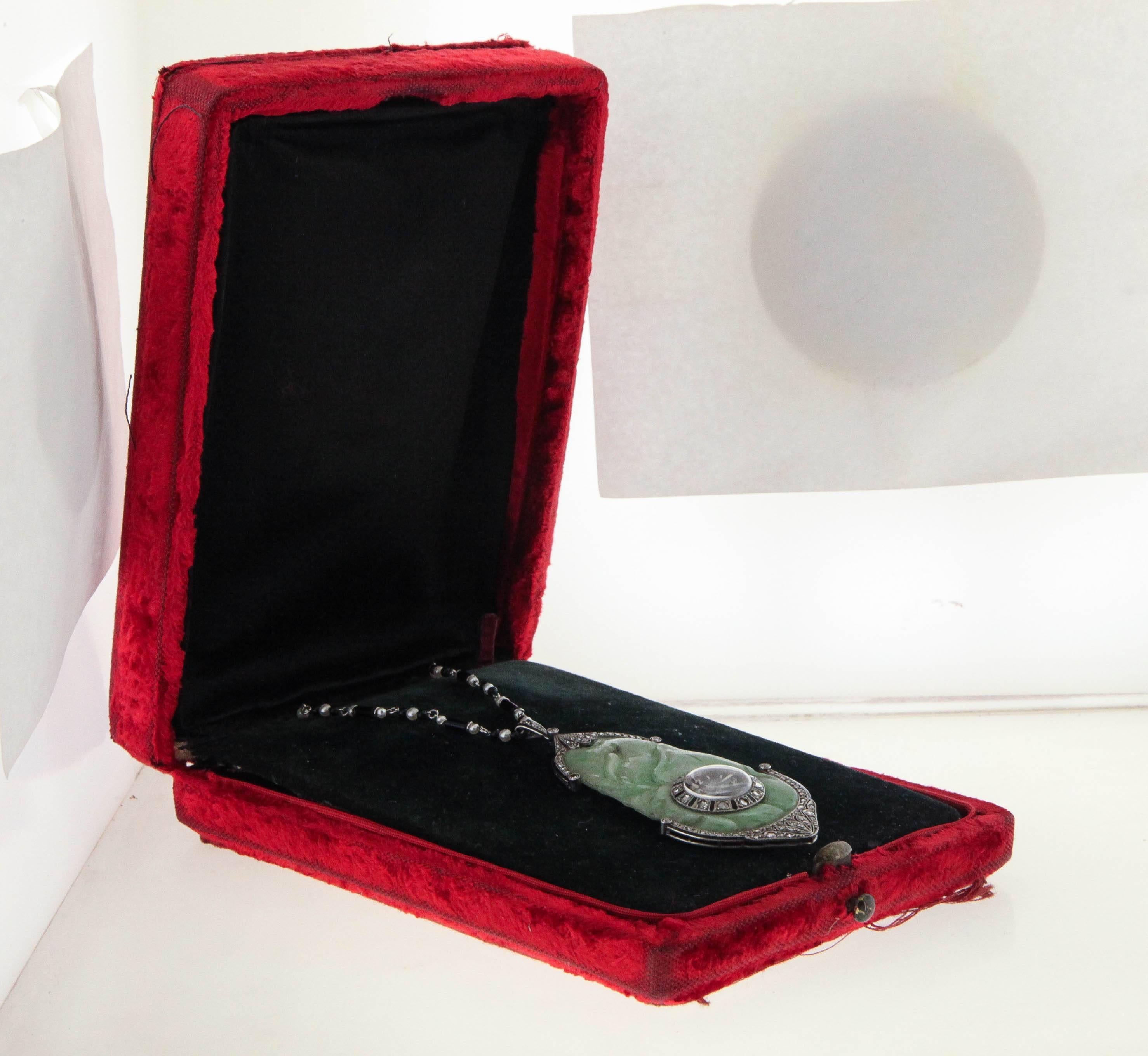 Art Deco jade and diamond pendant watch necklace, circa 1920's, made for the Buenos Aires retailer Ghiso. The carved jade pendant is framed top and bottom with platinum filigree framing set with rose-cut diamonds, the Jaeger LeCoultre watch inset