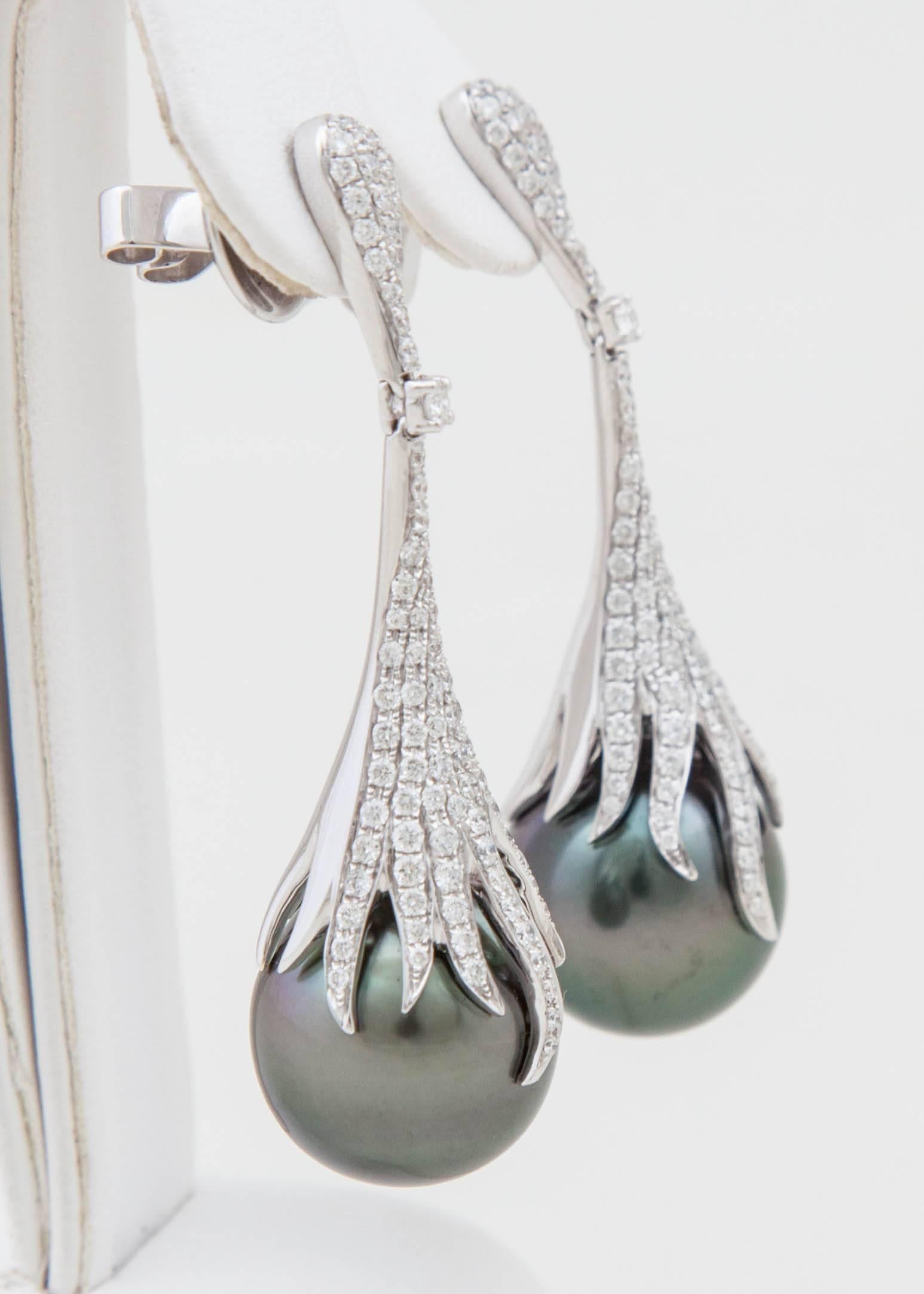 These Tahitian Pearl and diamond drop earrings add a beautiful twist on a classic drop earrings. The earrings consist of Natural Color 14x15mm Tahitian Pearls with 1.55 carats of diamonds set in 18k white gold. 

The length of these earrings is