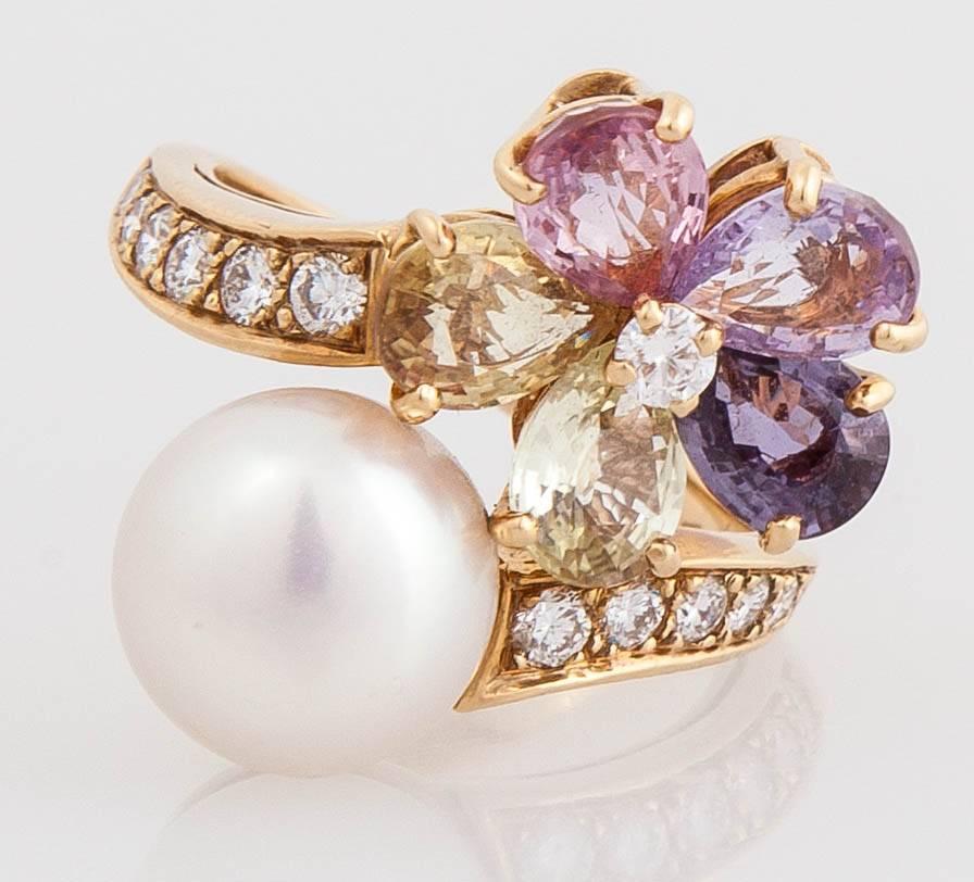 Finely crafted in 18k yellow gold with multicolored sapphires weighing 13.00 carats and a pearl.
The ring features round brilliant cut diamonds.
Signed by Bvlgari
Made in Italy
Size 7 1/4