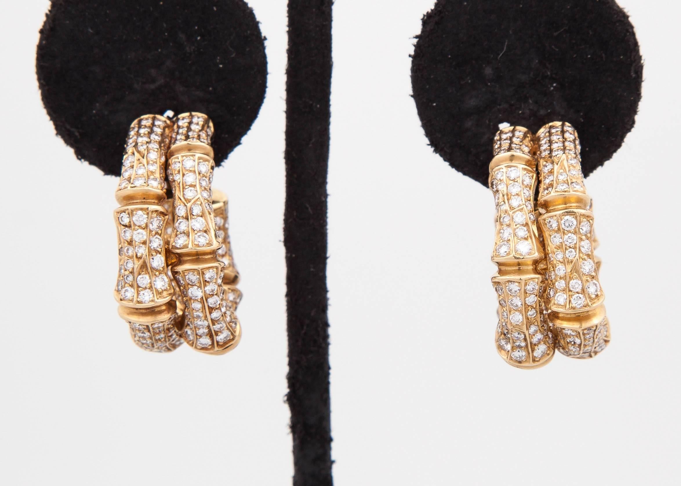 Splendid Cartier earrings, designed as a series of bamboo motif set with brilliant-cut diamonds, mounted in 18k yellow gold.