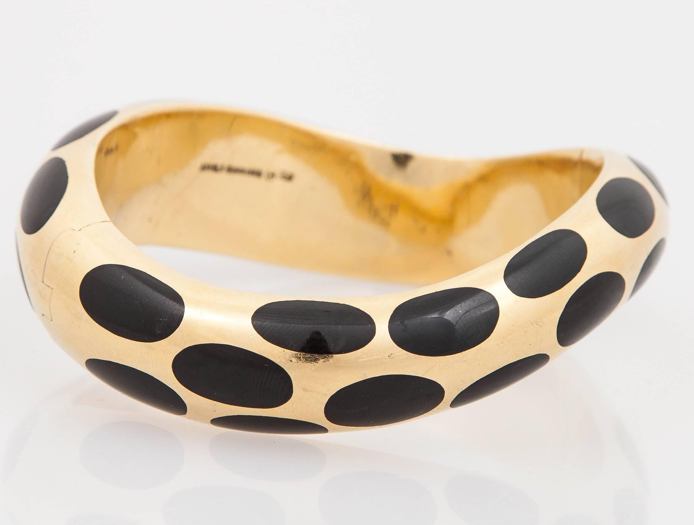 Spotted, Wavy Bangle by Angela Cummings for Tiffany and Co., is finely crafted in 18 k yellow gold with inlaid Onyx.