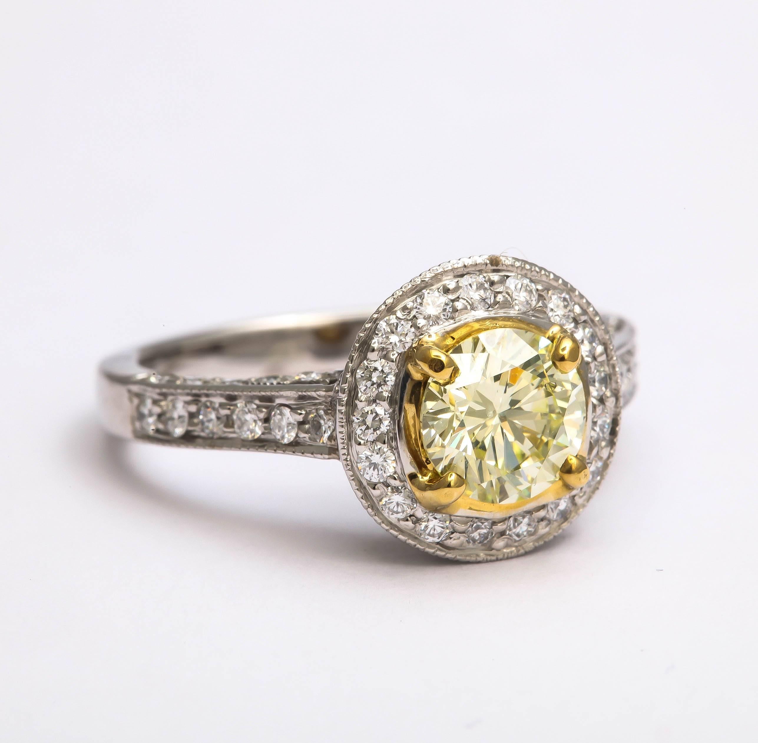 This lovely green yellow diamond weighs 1.05 cts. It is a natural color, SI 1 clarity and will be provided with a GIA certificate. The ring is made in platinum and 18 kt yellow and the center stone is surrounded in micro pave diamonds of F color, VS