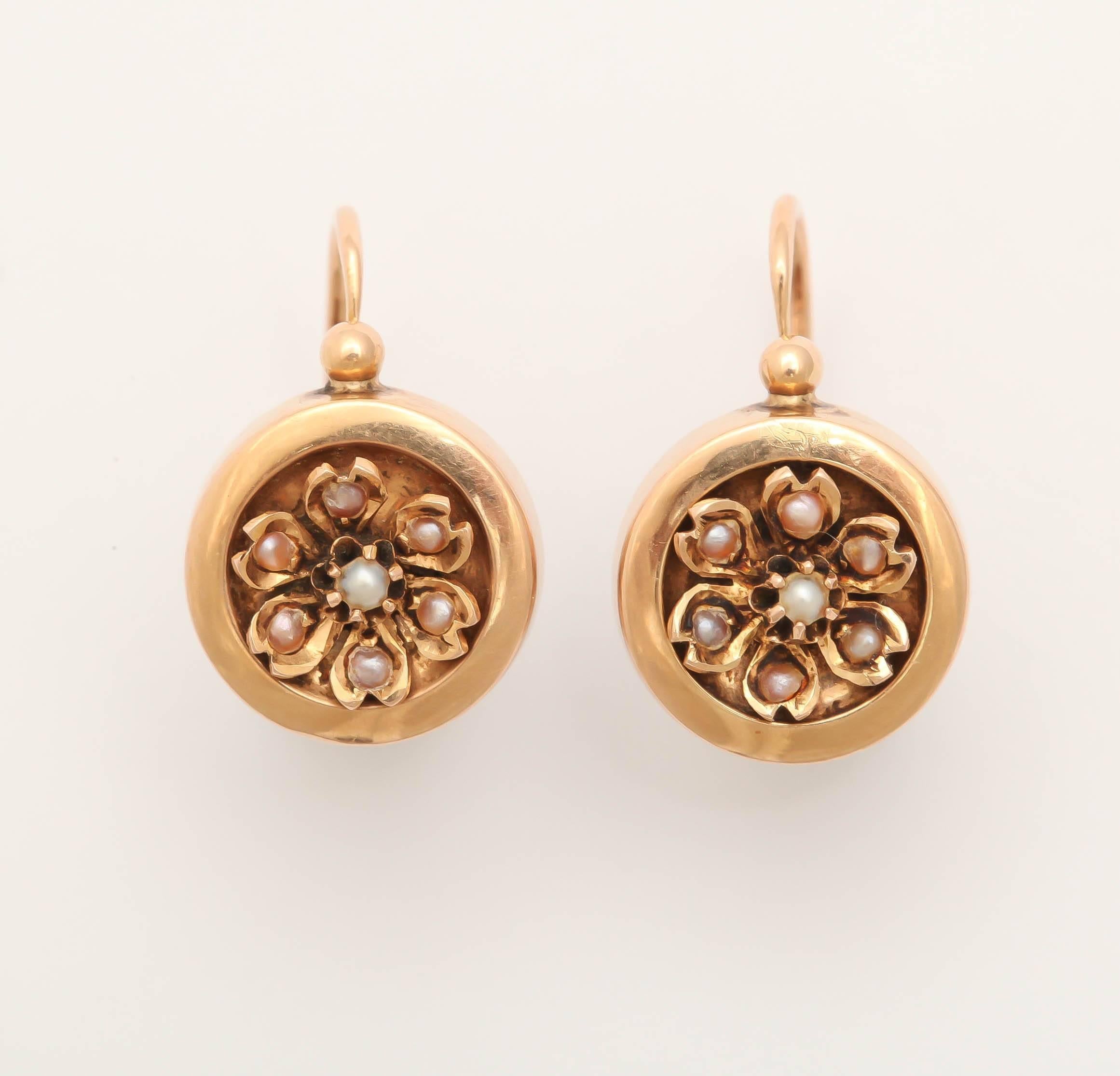 Of 18k rose gold enhanced with seed pearl flowers, attached to wires that open from the front of earring. All original, hallmarked.

France, 19th century. 

Earring 3/4 in. (1.9 cm); size of drop: