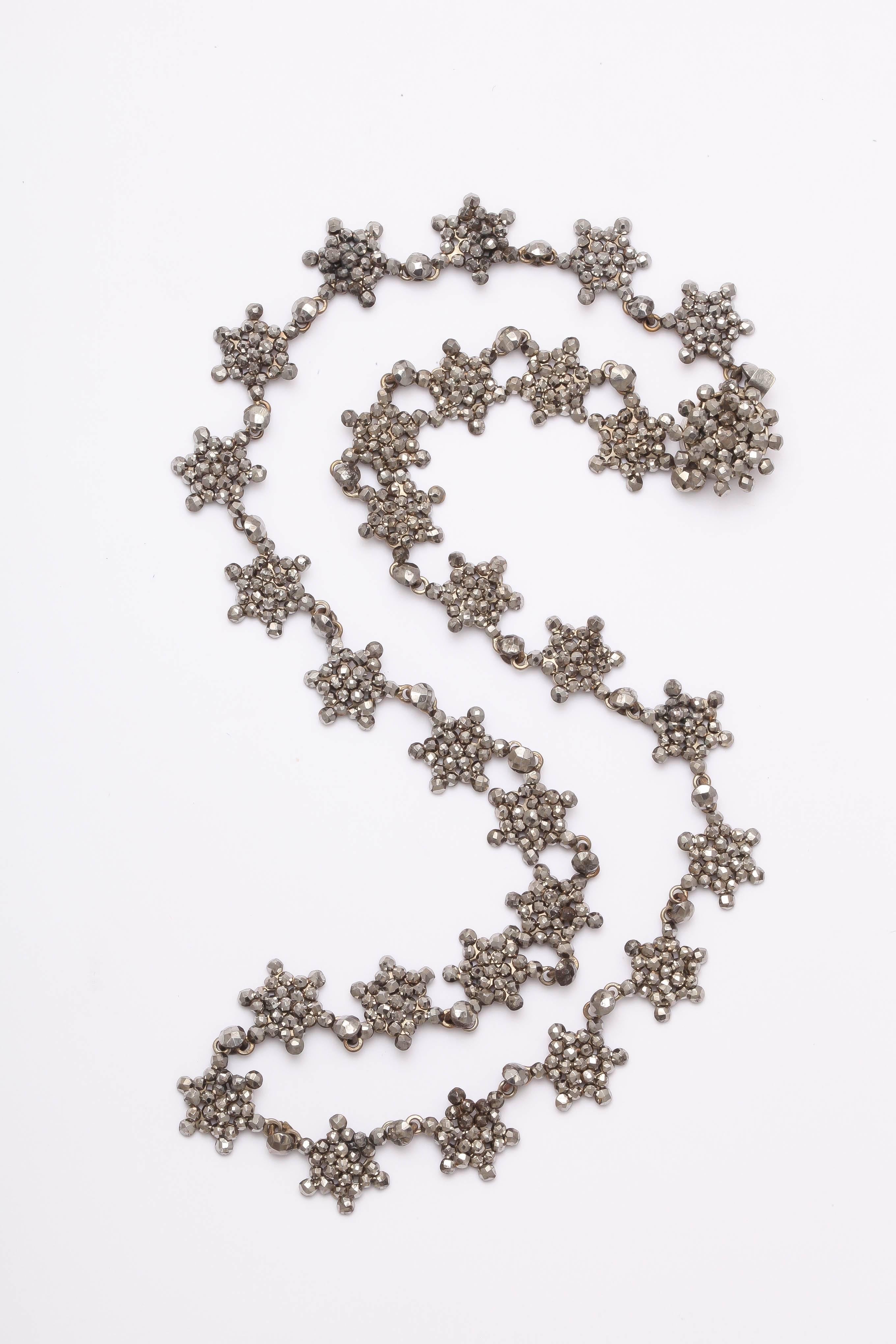 Minuscule bits of perfect, faceted cut steel, each cut and polished by hand c. 1830, are placed in small stars that fully encircle the neck with glittering twinkles. The necklace is dainty, feminine and all original. Note the clasp pretty enough to