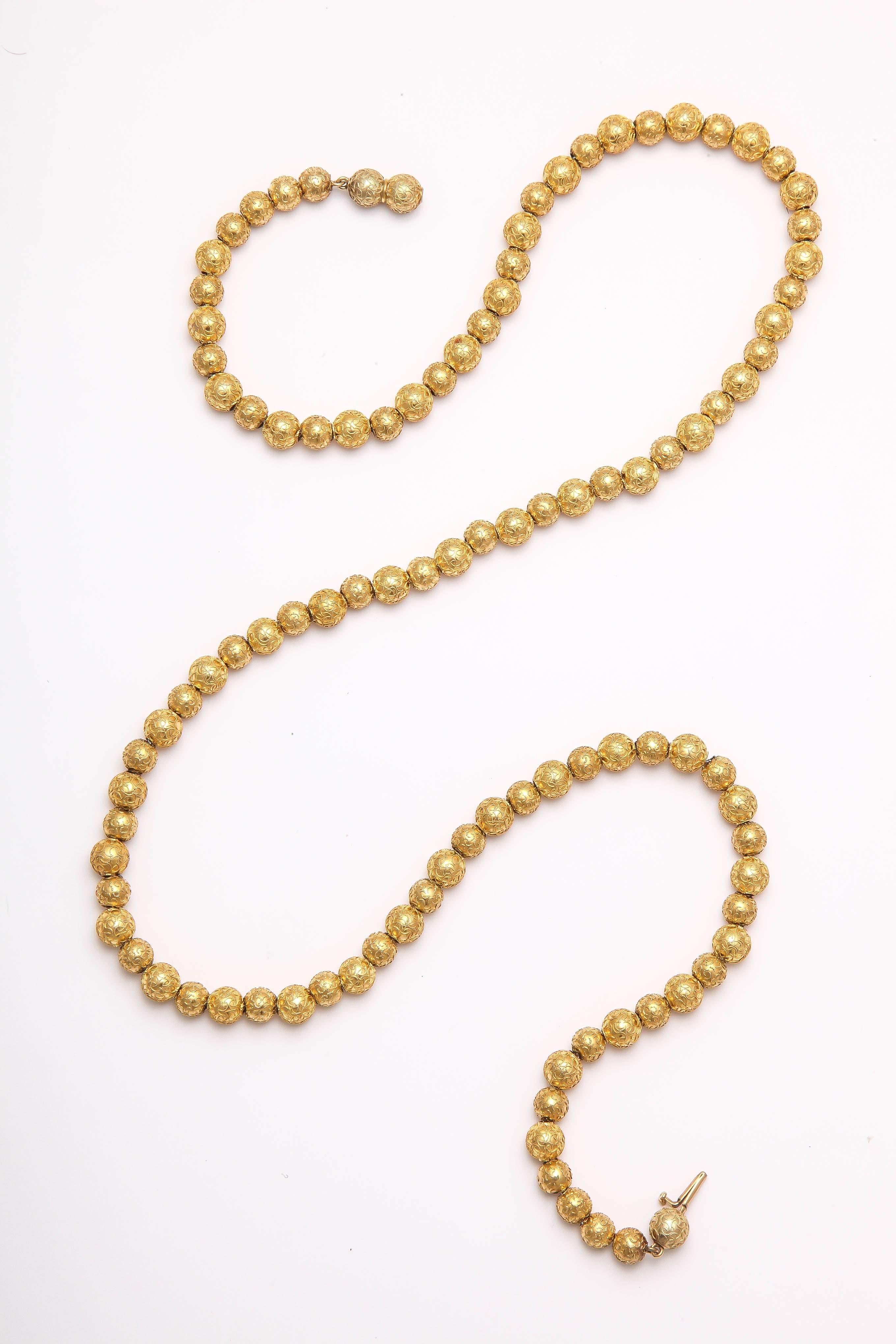 Generous engraving completely covers a long strand of 15 ct gold beads from the Victorian era c. 1870. The strand is strung on silver wire and is an example of  Victorian daytime jewelry as  seen in many portraits of the era. Beautiful in their