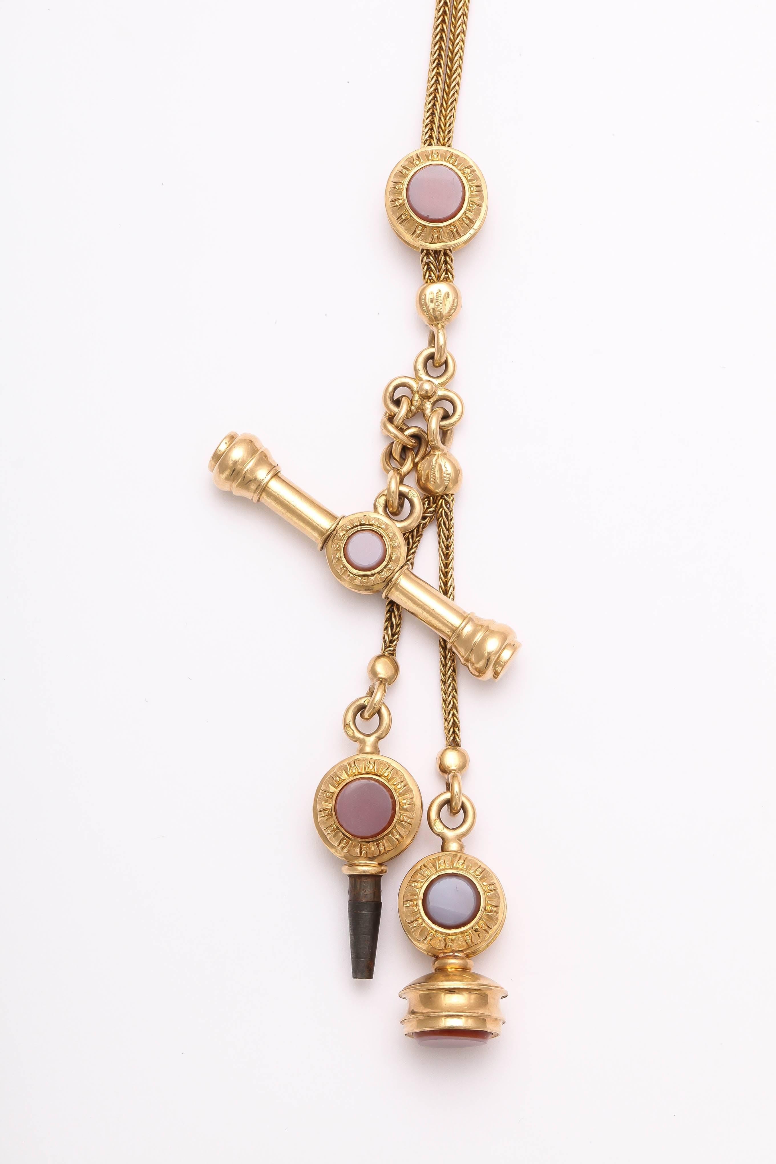 An unusual 18kt chain holding a toggle, fob, watch key and slide. All are  set with hard stone agates and are engraved to make the attachments look like flowers. The slide functions to hold the necklace closer to the nape of the neck or lower on the