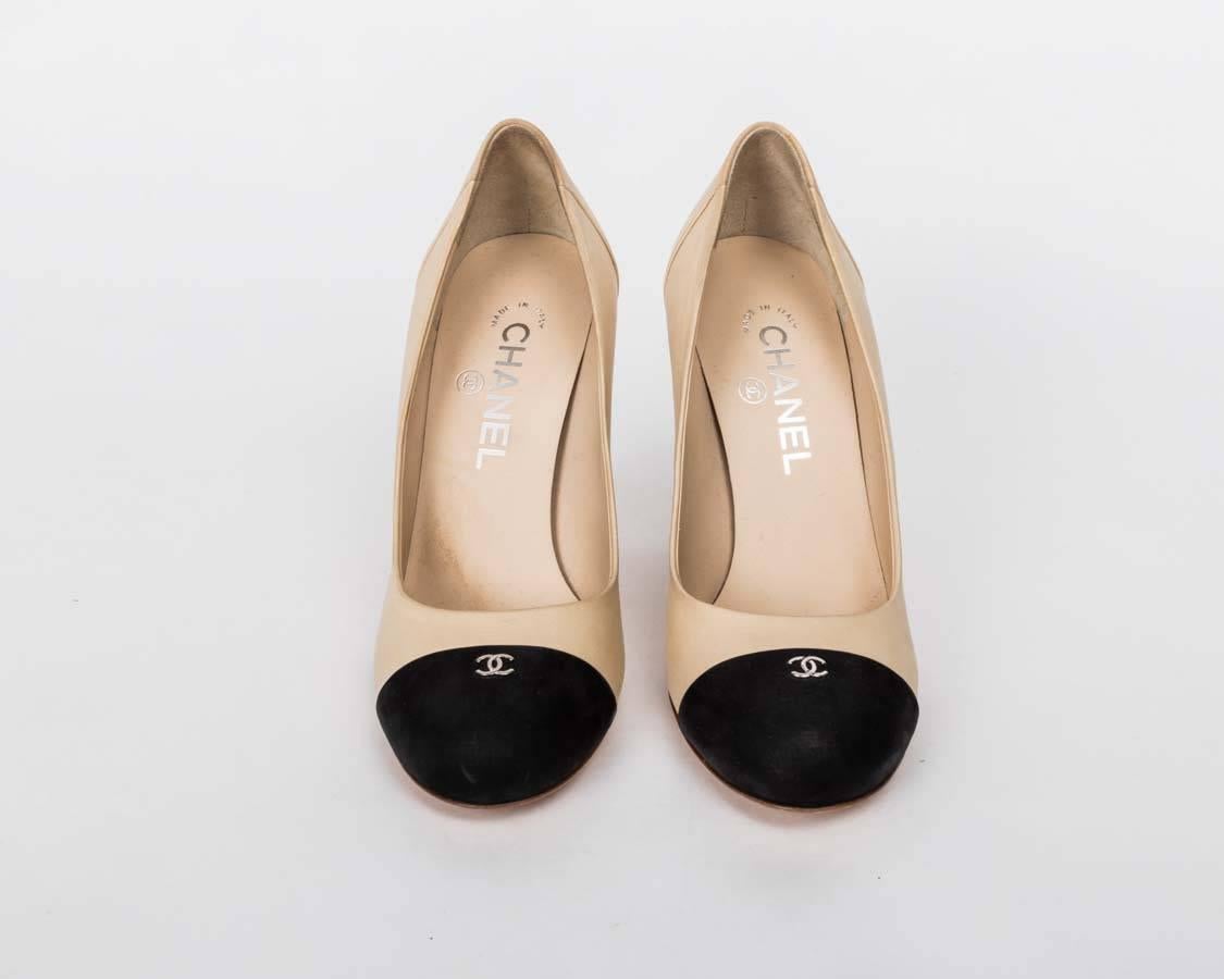 Chanel Beige & Black Lambskin CC Cap Toe Pump features include nude leather upper, black toe cap with silver- tone 