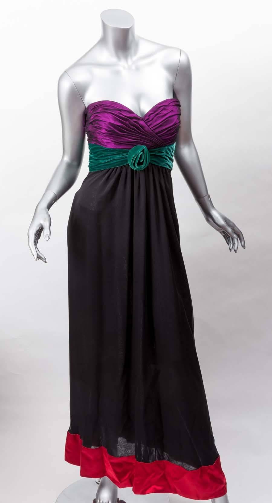 Vintage Oscar de la Renta Strapless Evening Gown features purple  bodice with black netting overlay,green velvet waist with rose center, long black silk skirt trimmed in red satin .