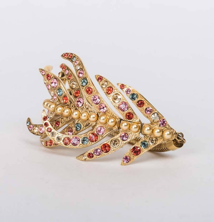 Louis Vuitton Crystal Leaf Bracelet features gold-tone leaf bracelet with faux multi-color crystals and pearl beads and clasp closure.