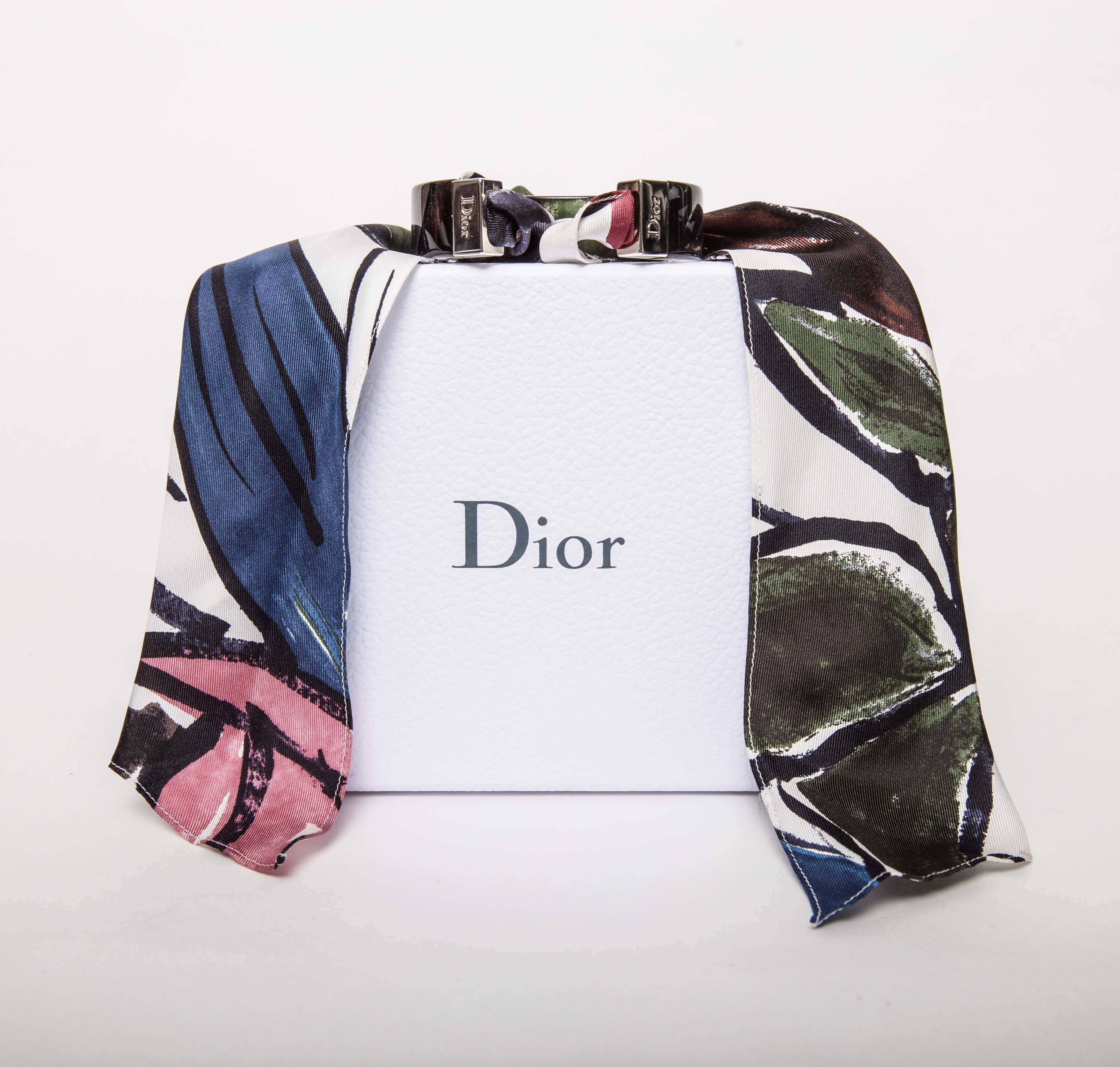 Christian Dior Scarf Bracelet featuring green, blue, pink, and neutral toned silk scarf attached to chunky Lucite cuff. 2015 Cruise Collection.
Comes with original box.
