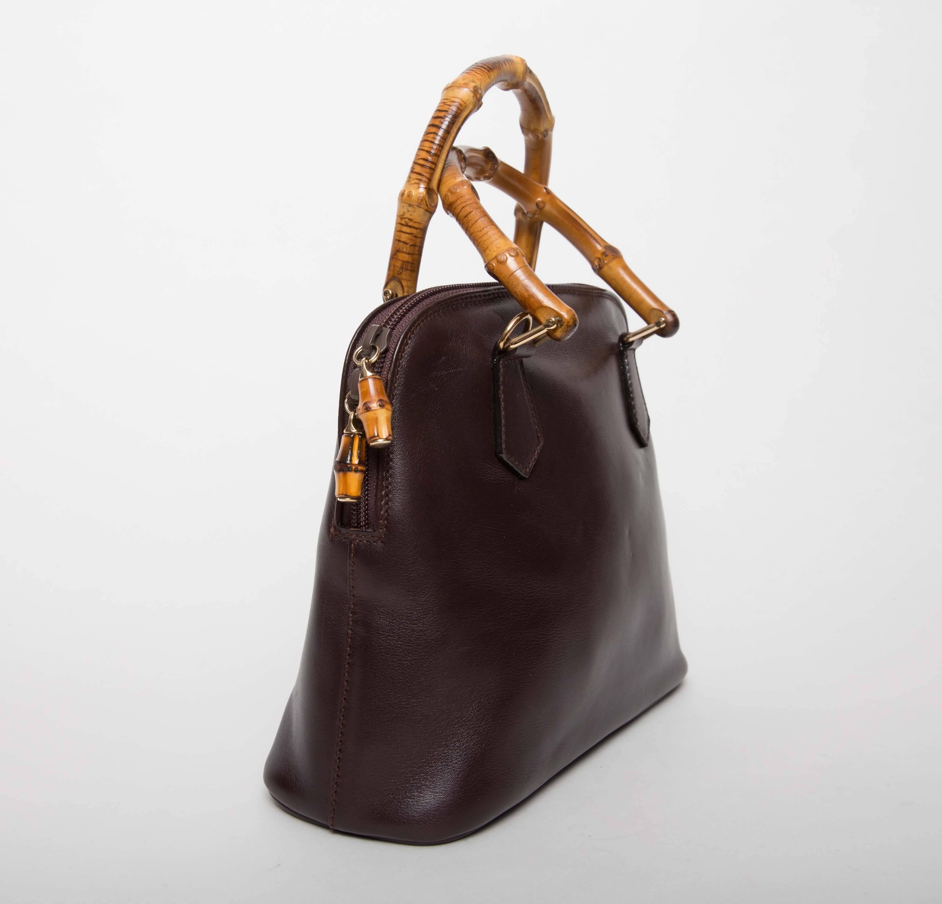  Gucci Vintage Alma Tote in Dark Brown Leather with Bamboo Handles features double bamboo wooden handles,
bamboo zipper fobs, top zip closure.  Five bottom feet,
inside one zip pocket.  This bag has original tags , removable cross body strap,
and