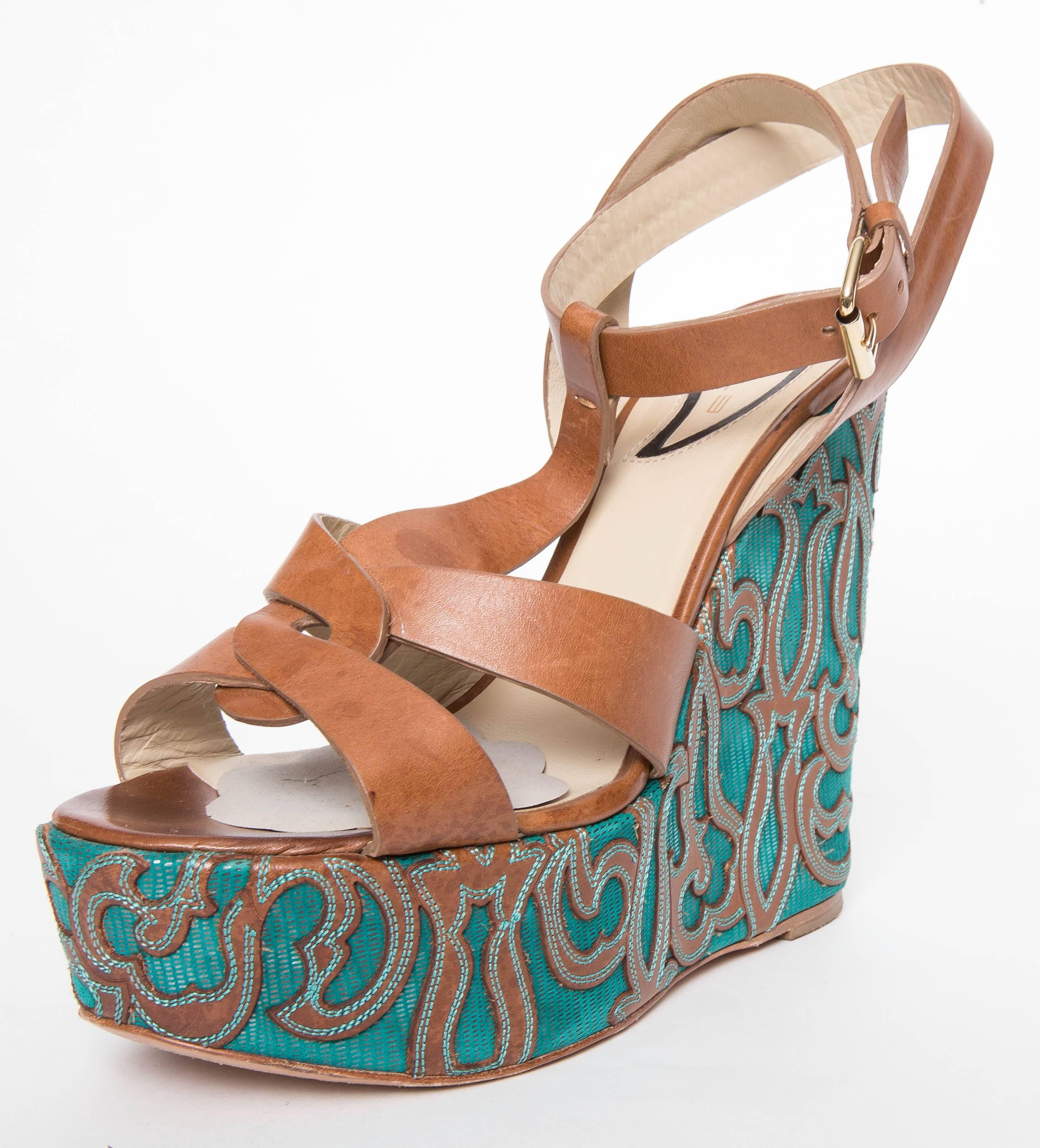 Etro Brown Leather and Turquoise Sole Wedged Sandals feature leather stitched brown design detailed wedge, crisscross adjustable ankle straps, and goldtone buckle.
Does not come with original box.