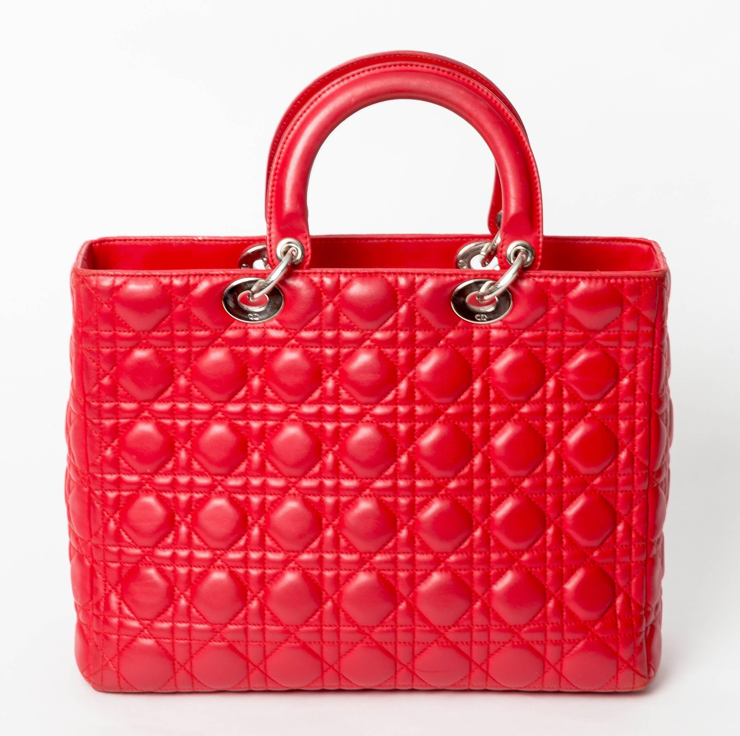 Christian Dior Large Lady Dior in Red Quilted Cannage Lambskin Tote features
double flat rigid leather top handles and a removable shoulder strap,single zip closure,Christian Dior jacquard textile lining, one large zippered interior pocket, and