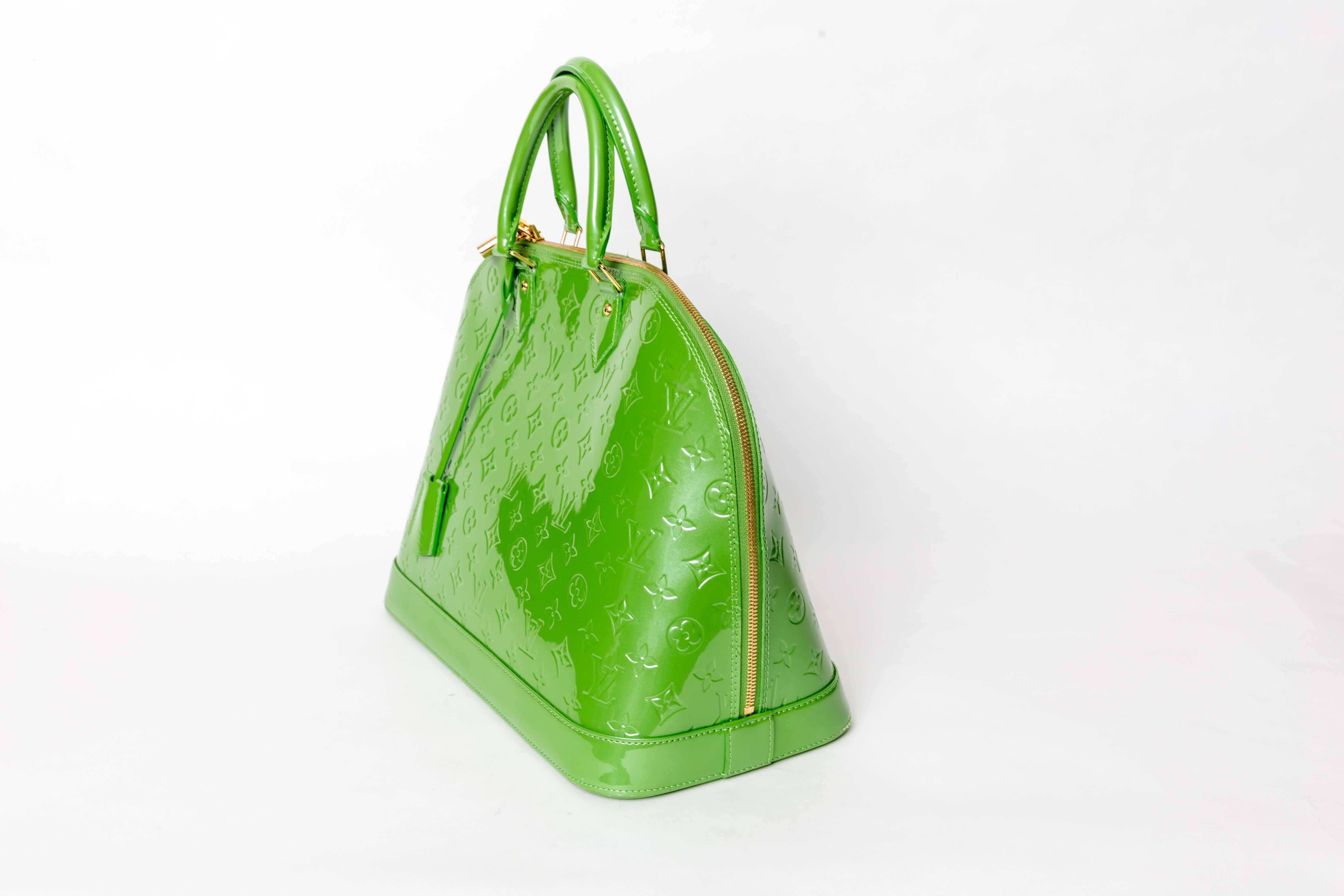 Louis Vuitton Alma Monogram Vernis GM features double rolled handles, protective base studs, leather clochette with key, and gold-tone hardware accents. The bag’s double zipper closure opens to fabric-lined interior with cellphone holder.
No