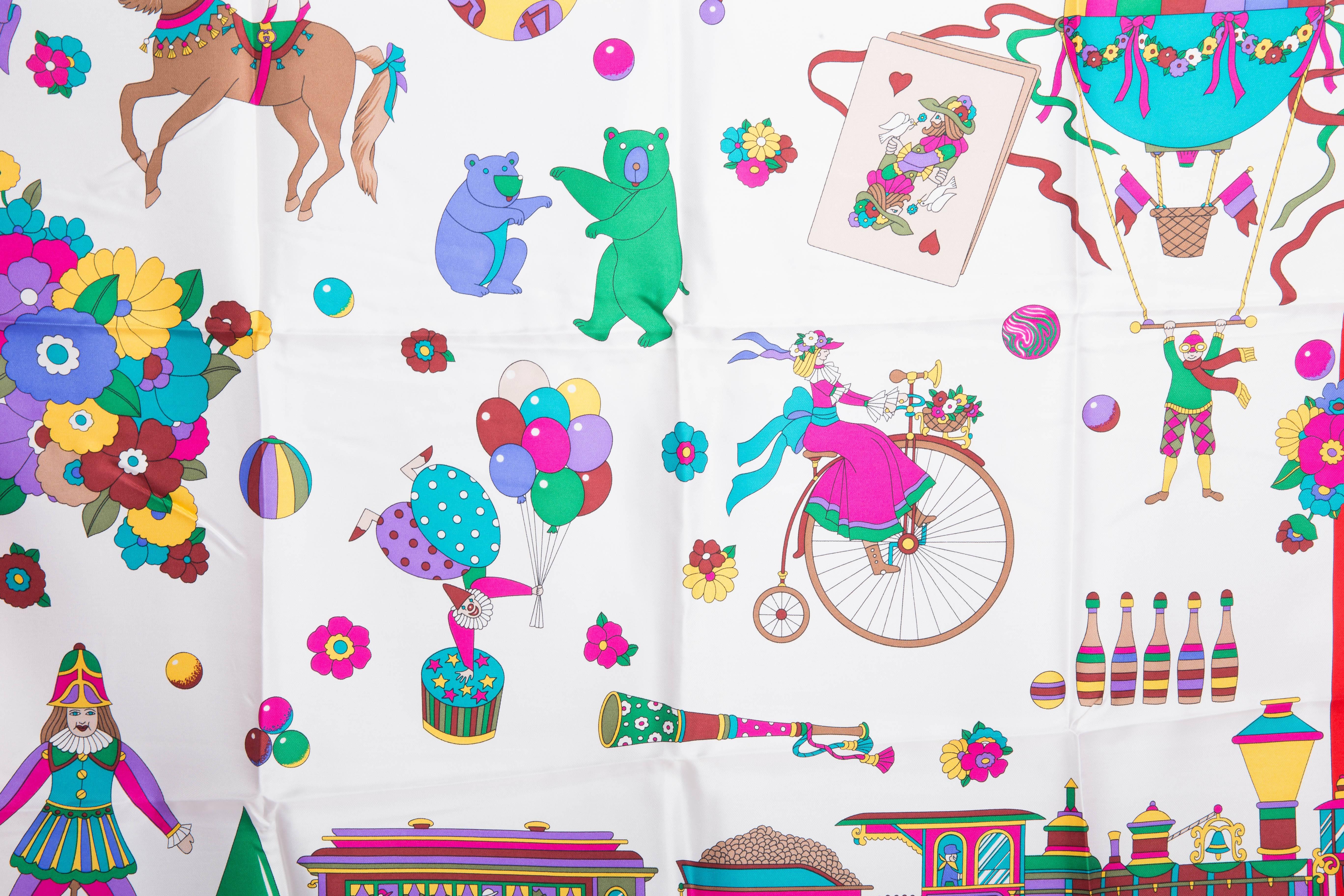 This vintage Gucci scarf has never been used and its original Gucci tags are still attached. Part of Gucci's circus collection, this silk scarf features a red border with purple rolled hem. Whimsical bears, clowns and performers appear throughout. 
