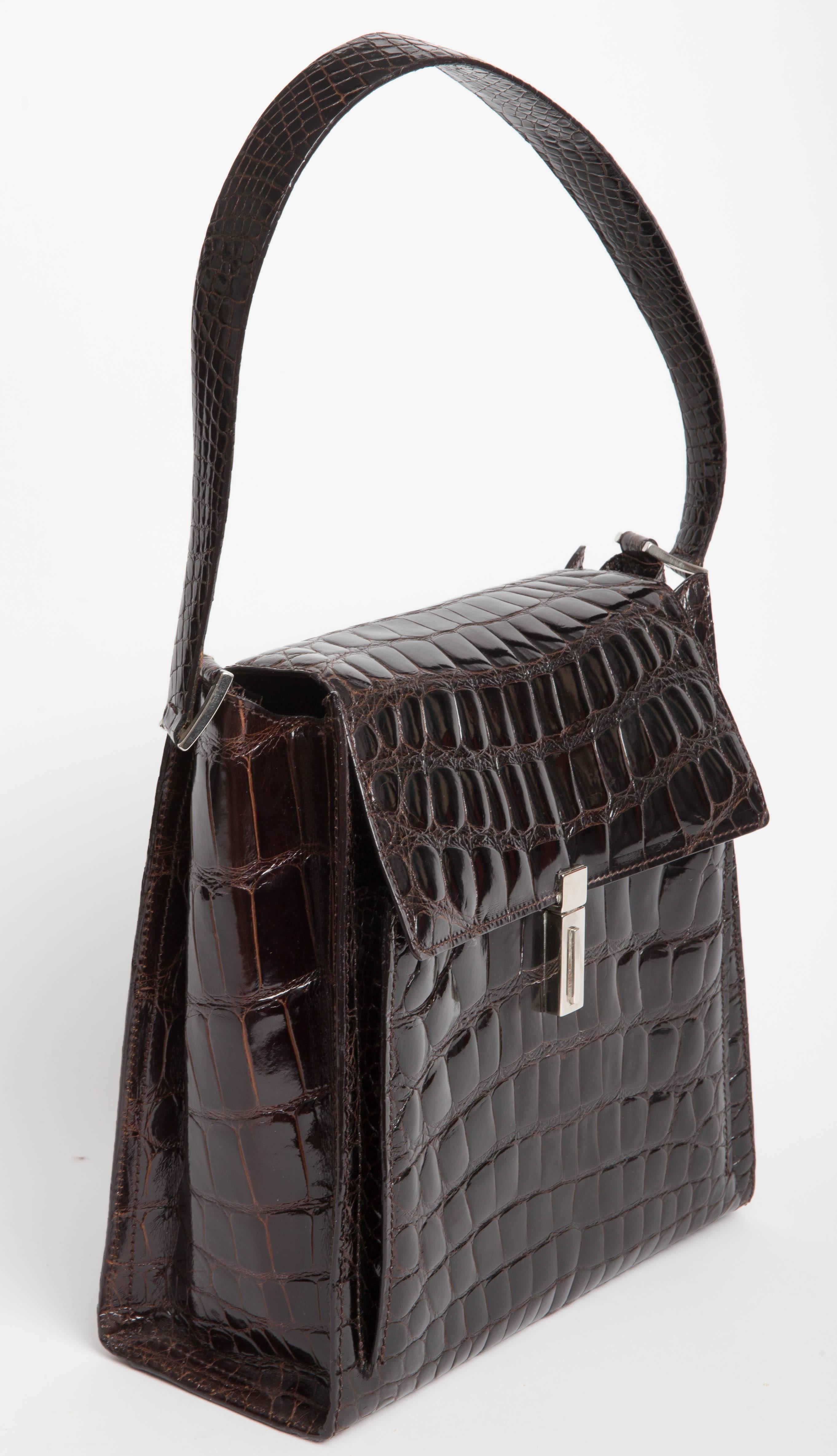 Rich chocolate brown Alligator Shoulder Bag by Tardini. New with tags, this bag has a Barney's price tag of $5495. Interior is lined in beige pigskin. There is an interior zip pocket as well as an outside pocket. This bag has been sitting in our