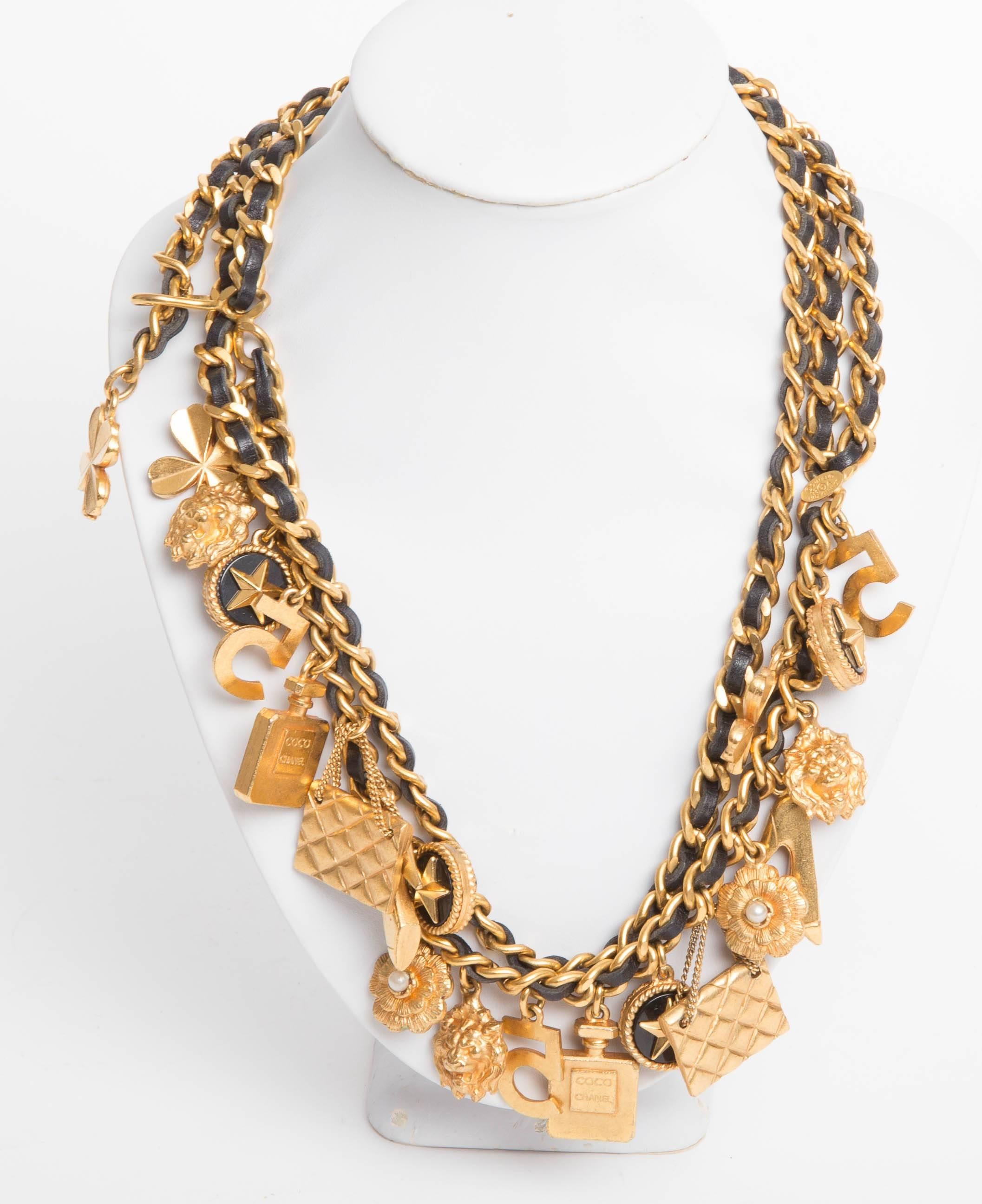 CHANEL vintage iconic chain link charm belt/necklace. Gold tone chain with woven black leather featuring twenty one iconic charms from the House : 4-leaf clover, Leo the lion, lucky star, 