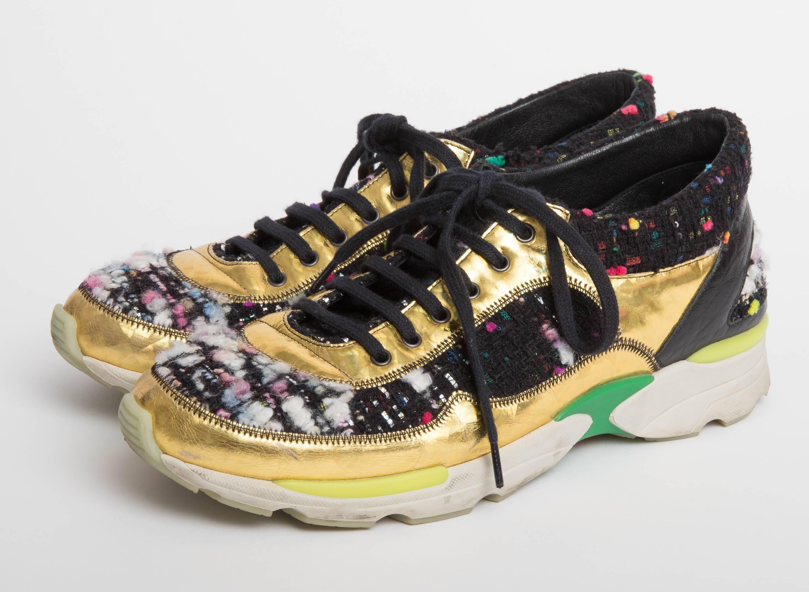 Chanel  Metallic Boucle Sneakers EU9 feature black and multicolor Chanel bouclé sneakers with gold holographic leather trim, black leather trim at counters, rubber soles and front lace-up tie closures.
From the Fall 2014 Collection.
Does not come