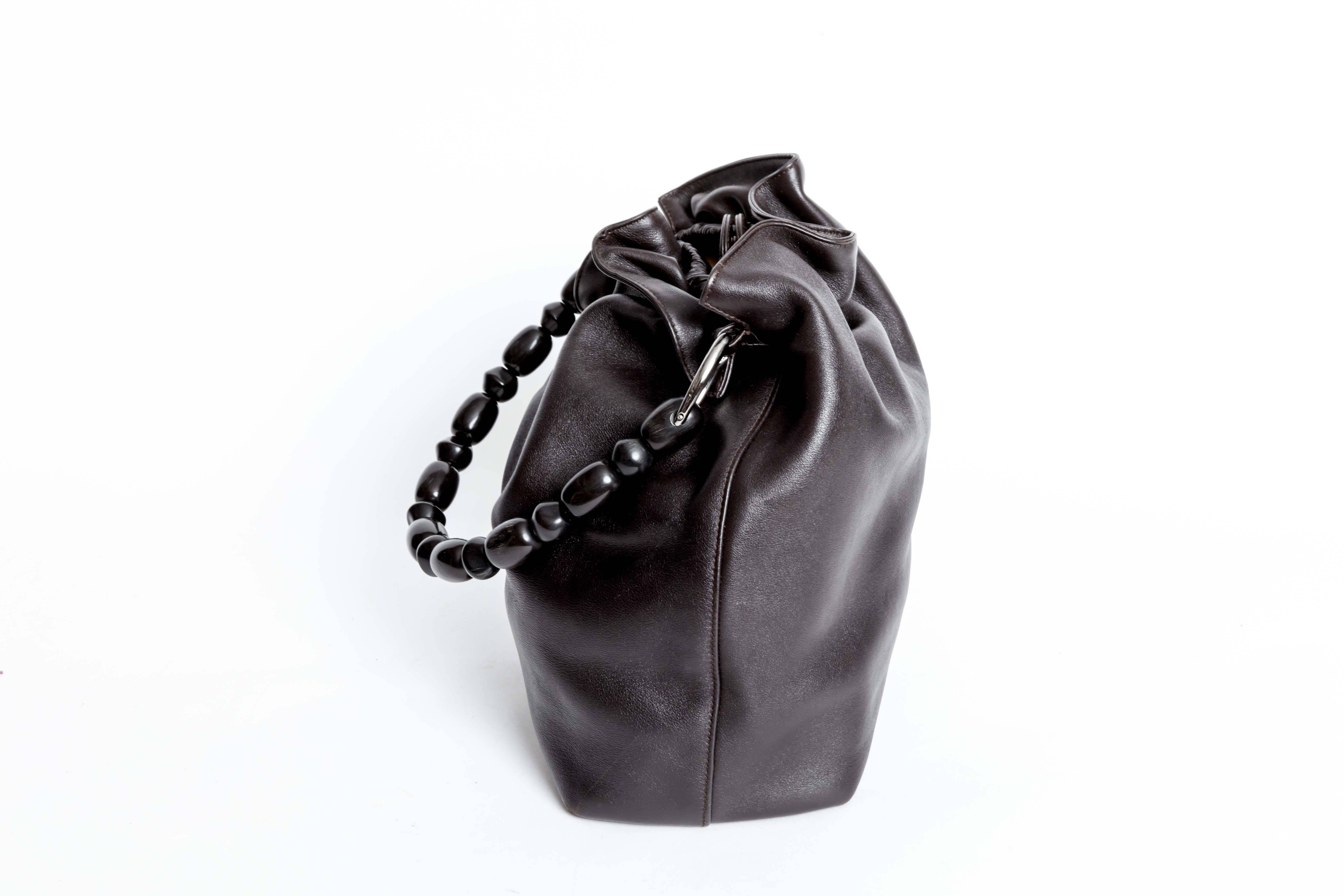 Christian Dior Black Leather Silver Tone Beaded Handle Malice Tote Handbag features silver tone hardware, magnetic closure, beaded handle, three interior pockets, and fabric lining.
Comes with authenticity cards.
Does not come with original