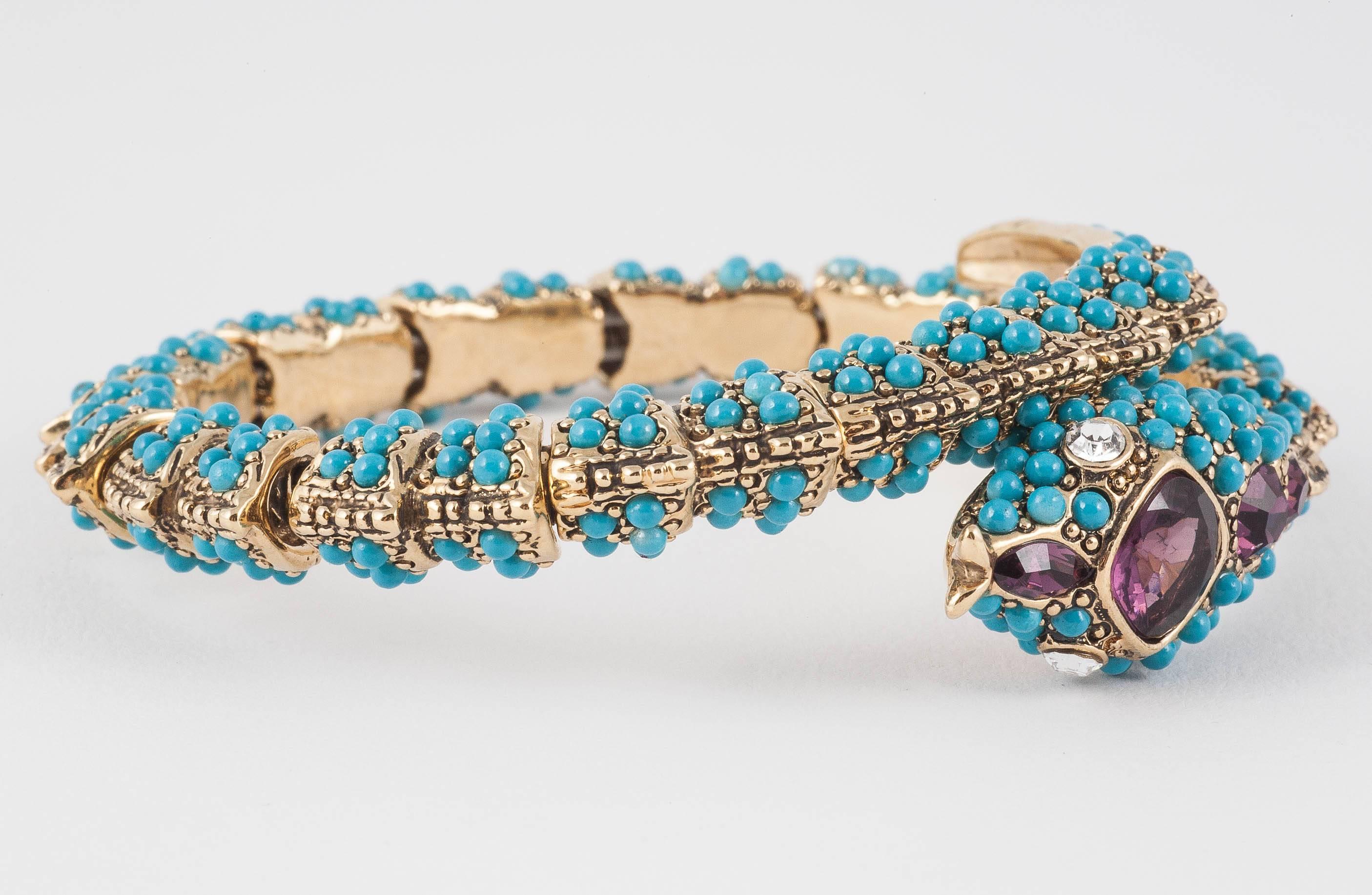 This lightly sprung and flexible 'KJL' (Kenneth Jay Lane) 'snake' bangle/bracelet is delicately decorated with tiny turquoise cabuchons and amethyst paste decoration on the head of the serpent. Imitating exquisite Victorian and Georgian jewellery,