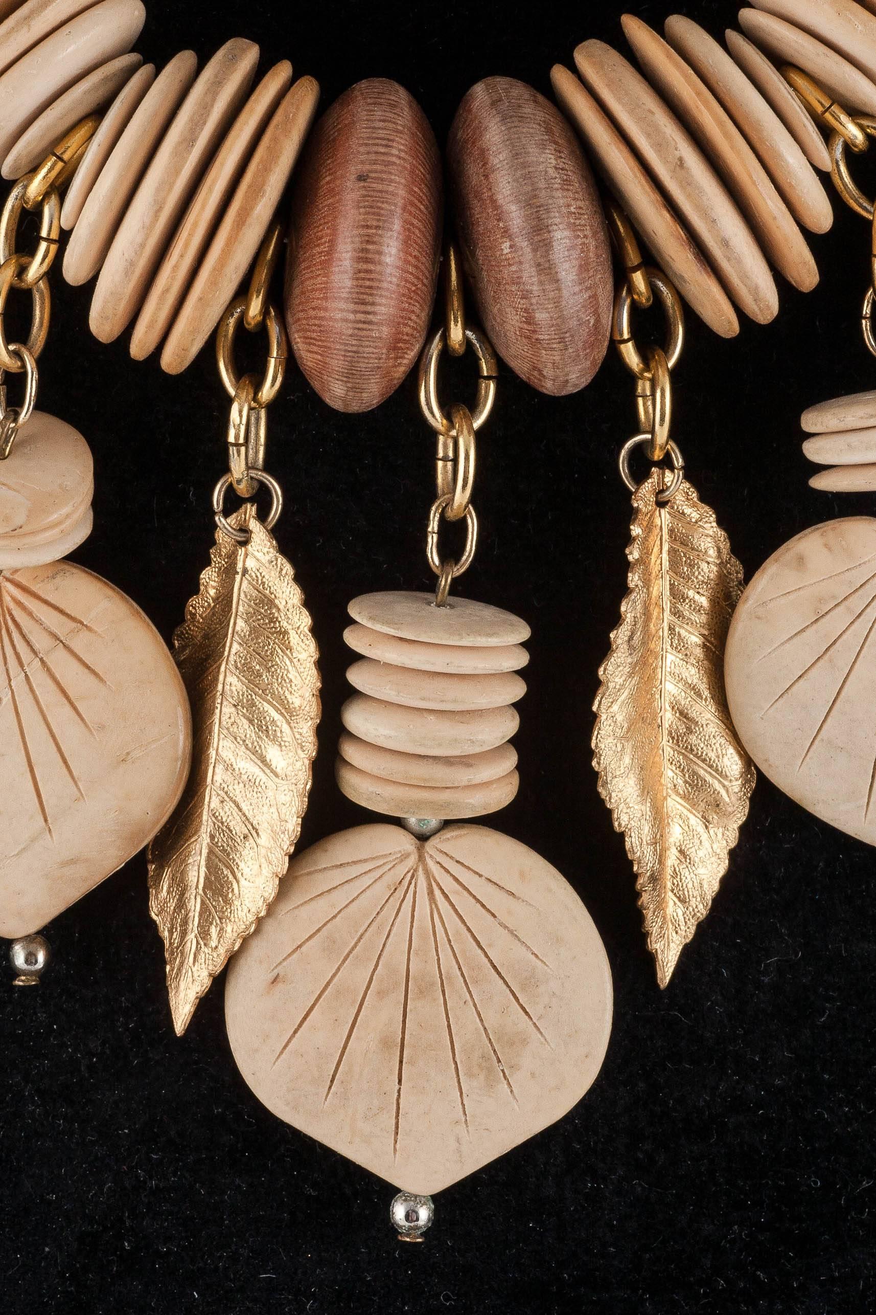 A light, fun necklace made of pale and darker wood discs with suspended gilt leaves, just right for holiday dressing. Bought in the South of France and no doubt worn with macrame and cheese cloth, this has a lovely bohemian look but also peaks of