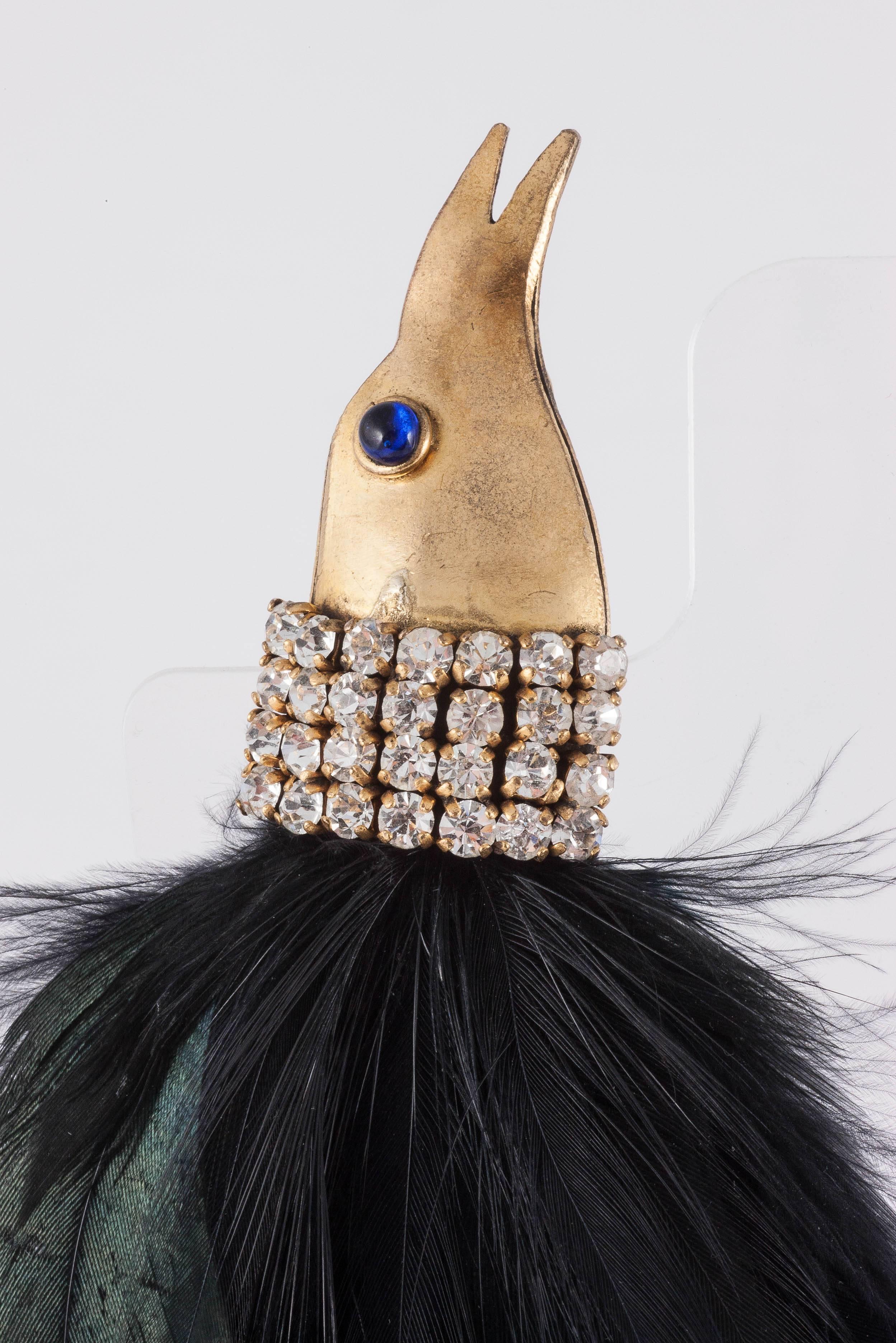 Magnificent and opulent large 'Bird Of Paradise' earrings by Isabel Canovas, made from gilded metal and lush feathers with clear and sapphire paste highlights. The earrings are naturally clip on and hang down , with the bird's head on the earlobe,