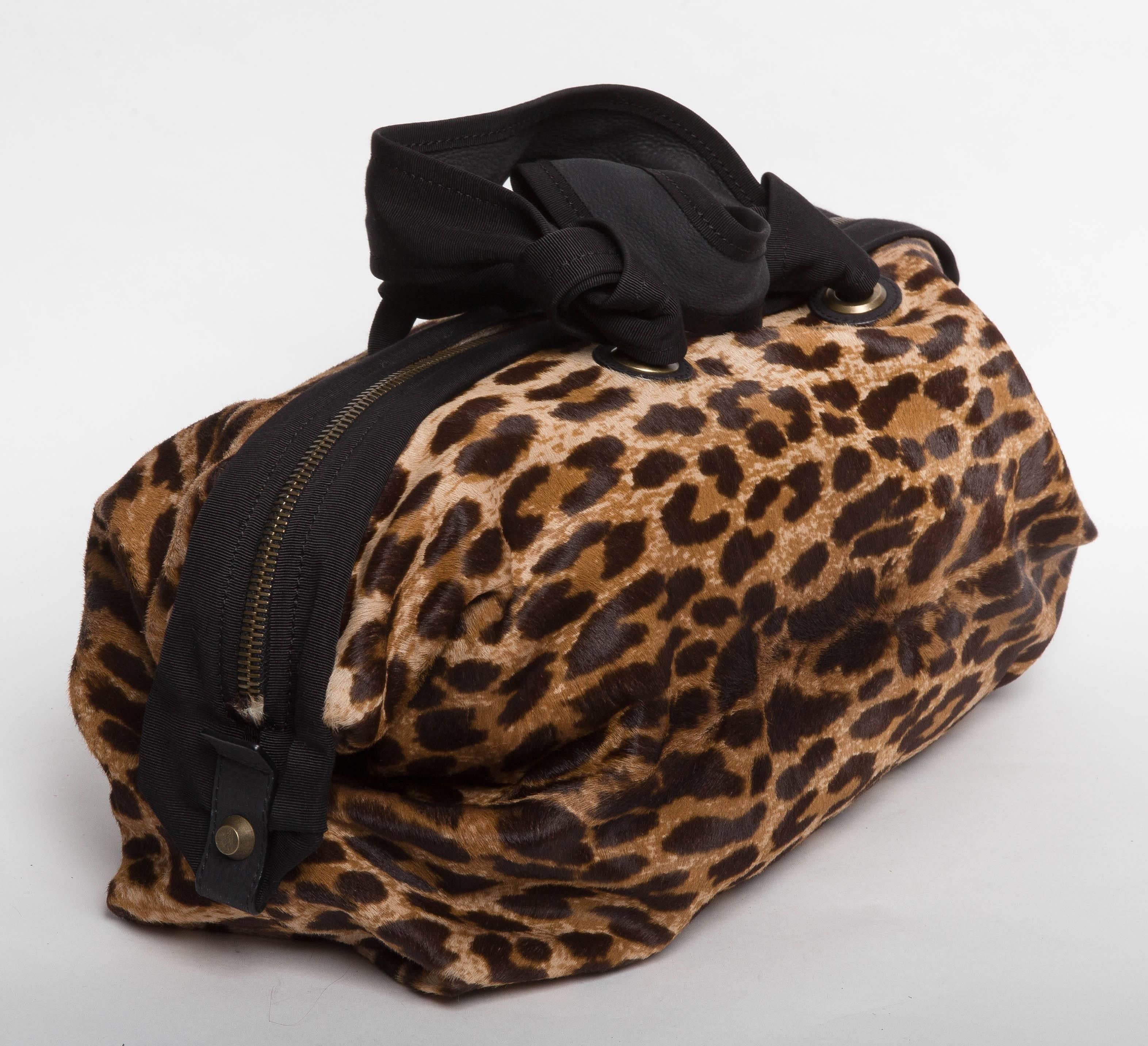 Very chic Lanvin pony skin bag in a cheetah animal print. Black grosgrain trim double handles and trim. Zips across the top of the bag. Large enough to use as a travelling tote or for every day use, this bag is in excellent condition. Four metal