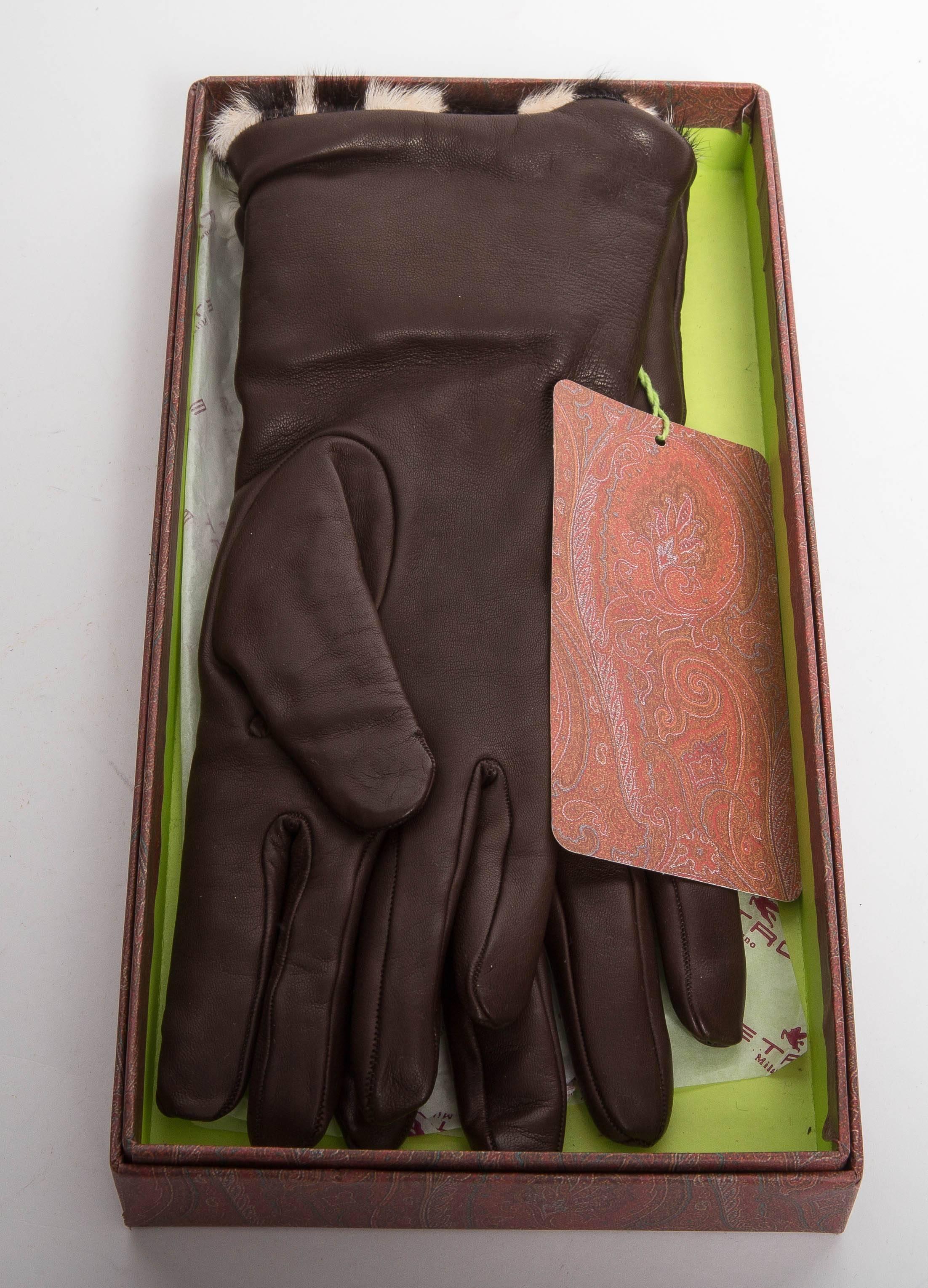 Very Elegant Size 6 Etro Lambskin Gloves Lined in Rabbit Fur. These gloves are long enough to cover the wrist with ease and feature a snap closure with leather tab  at the top of the glove. The fur subtly  peeks above the top of the glove.