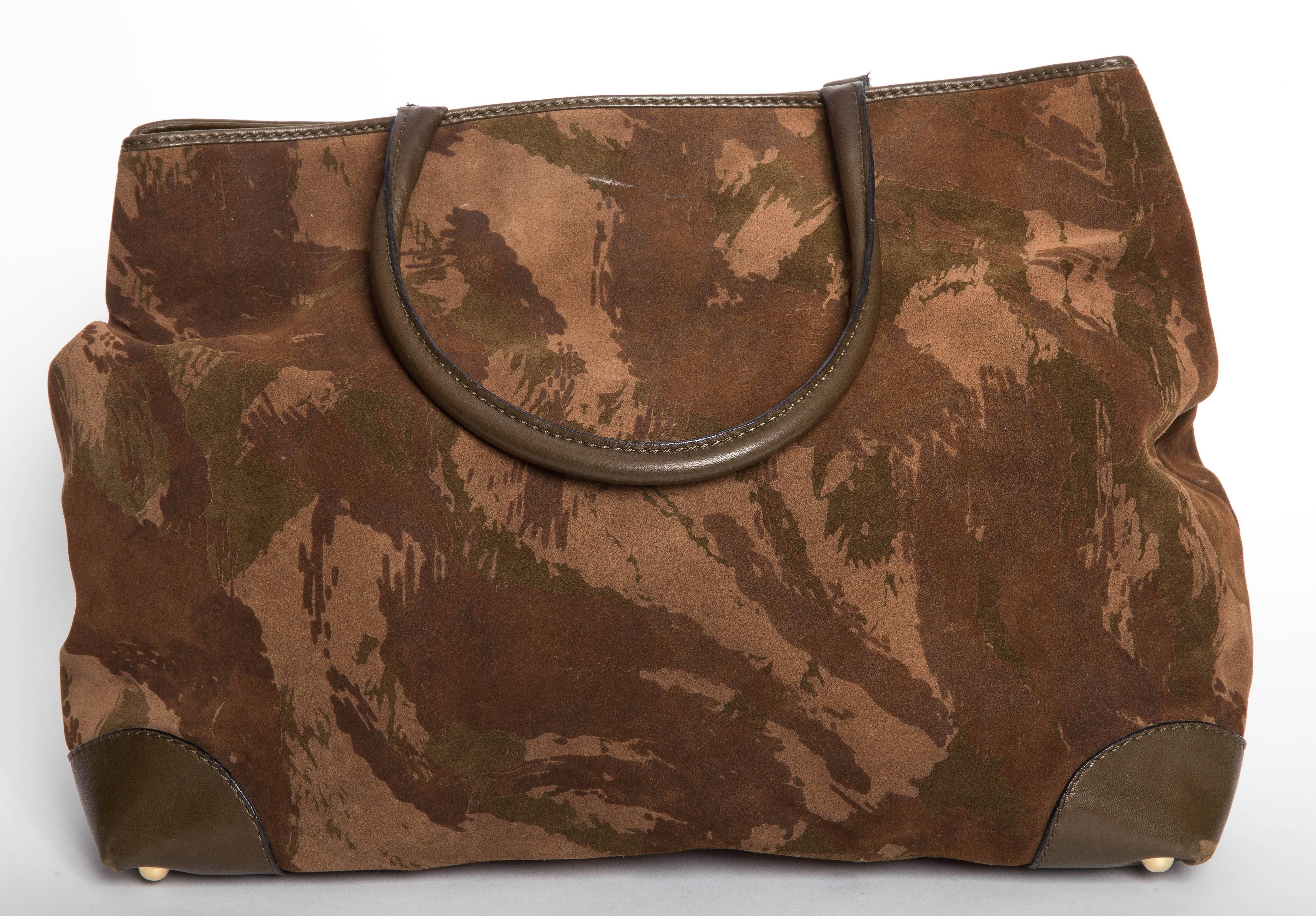 Bottega Veneta Camouflage Suede Tote with Double Leather Handles and Leather Trim and Leather Corners with four brass feet. The interior of the bag is lined in polished cotton and features a large zipper pocket. There is some soiling to the lining