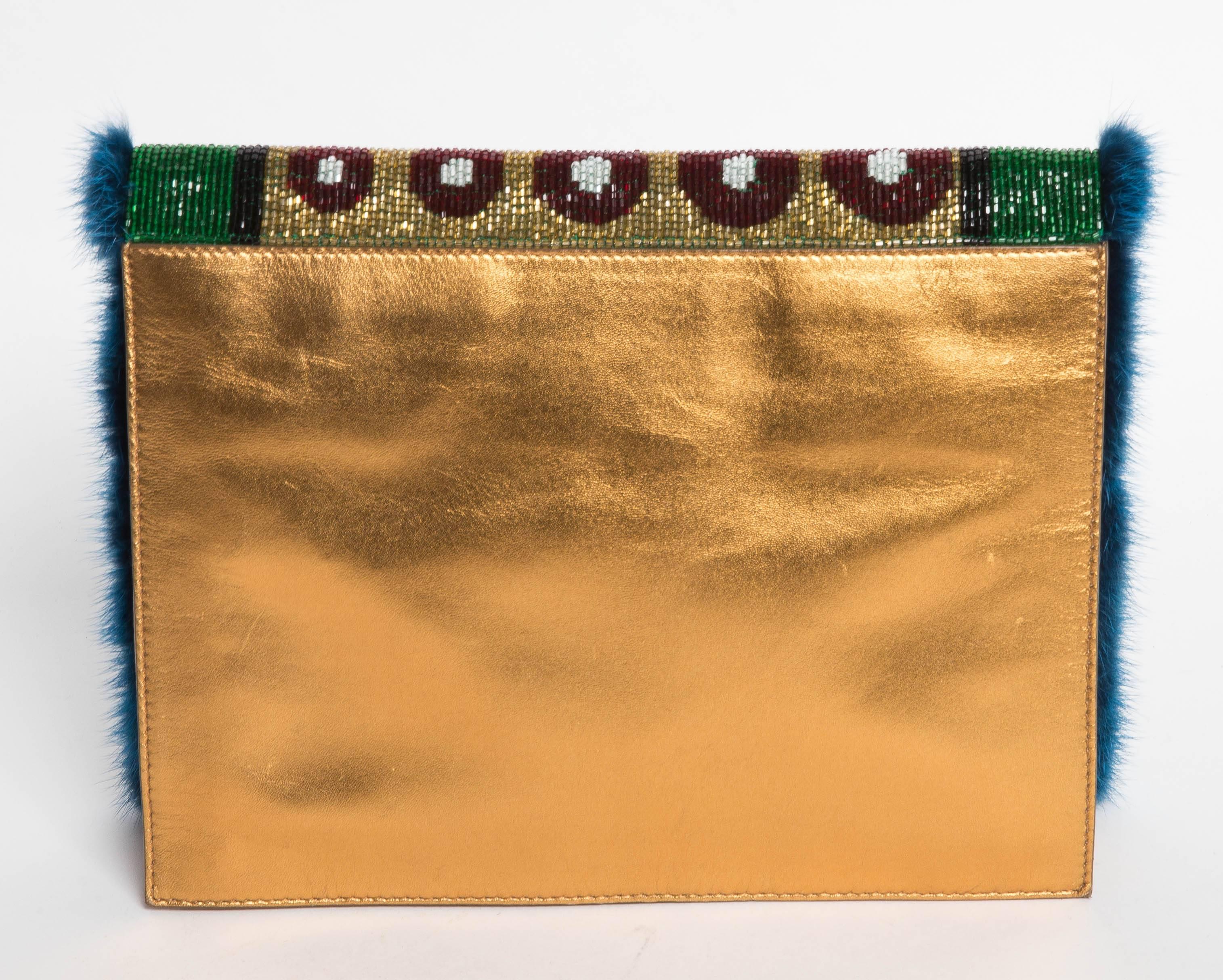 Beaded Fendi Shoulder Bag in Gold Leather with luxe Teal Blue Mink Trim. 
Garnet, White, Gold, Emerald and Black Beads Adorn the Front Flap of this Stunning Bag.The Interior of the bag is lined in Gold Satin with one Zip Pocket while the inner flap