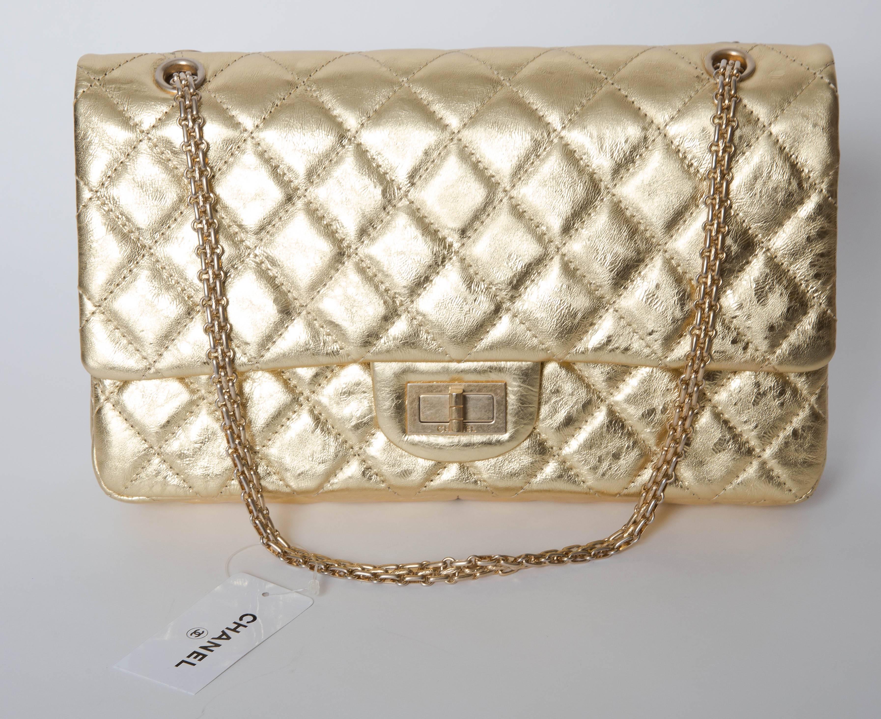  Metallic gold-tone quilted leather Chanel Reissue 227 Double Flap Bag with gold hardware, dual chain-link shoulder straps, exterior flap pocket, two interior pockets and a third pocket featuring a zip closure. Mademoiselle turn-lock closure at