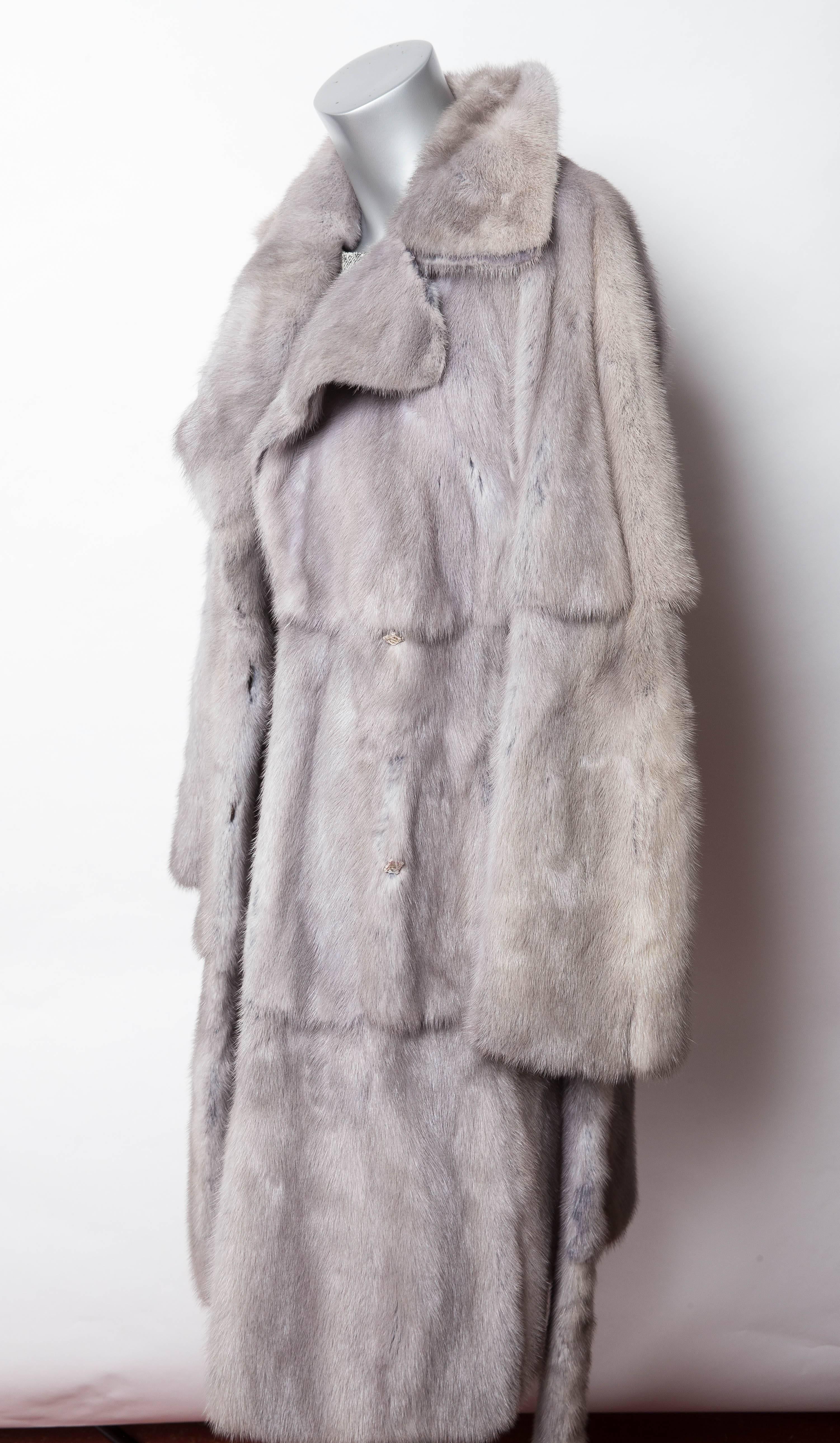 Stunning Fendi Mink Coat with Blue Suede Lined Double Lapels and Mink Belt.
The base of the mink is dyed blue so that a hint of color appears when the mink is brushed.
The double flap lapels have an inner lining of blue suede so that once again,