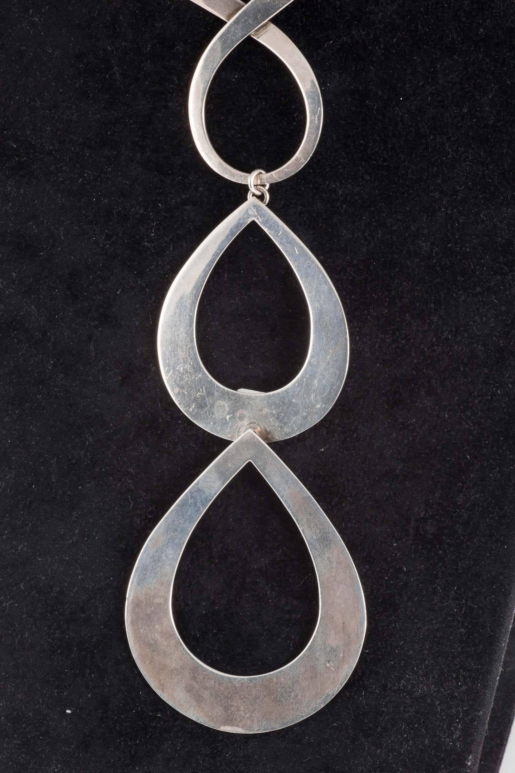 This is a show stopping piece of 60s jewellery which benefits from being beautifully crafted. It is all smooth plates of twisted flat sterling silver, simply linked with rings. It sits close to the neck but then the loops fall to below the bust.