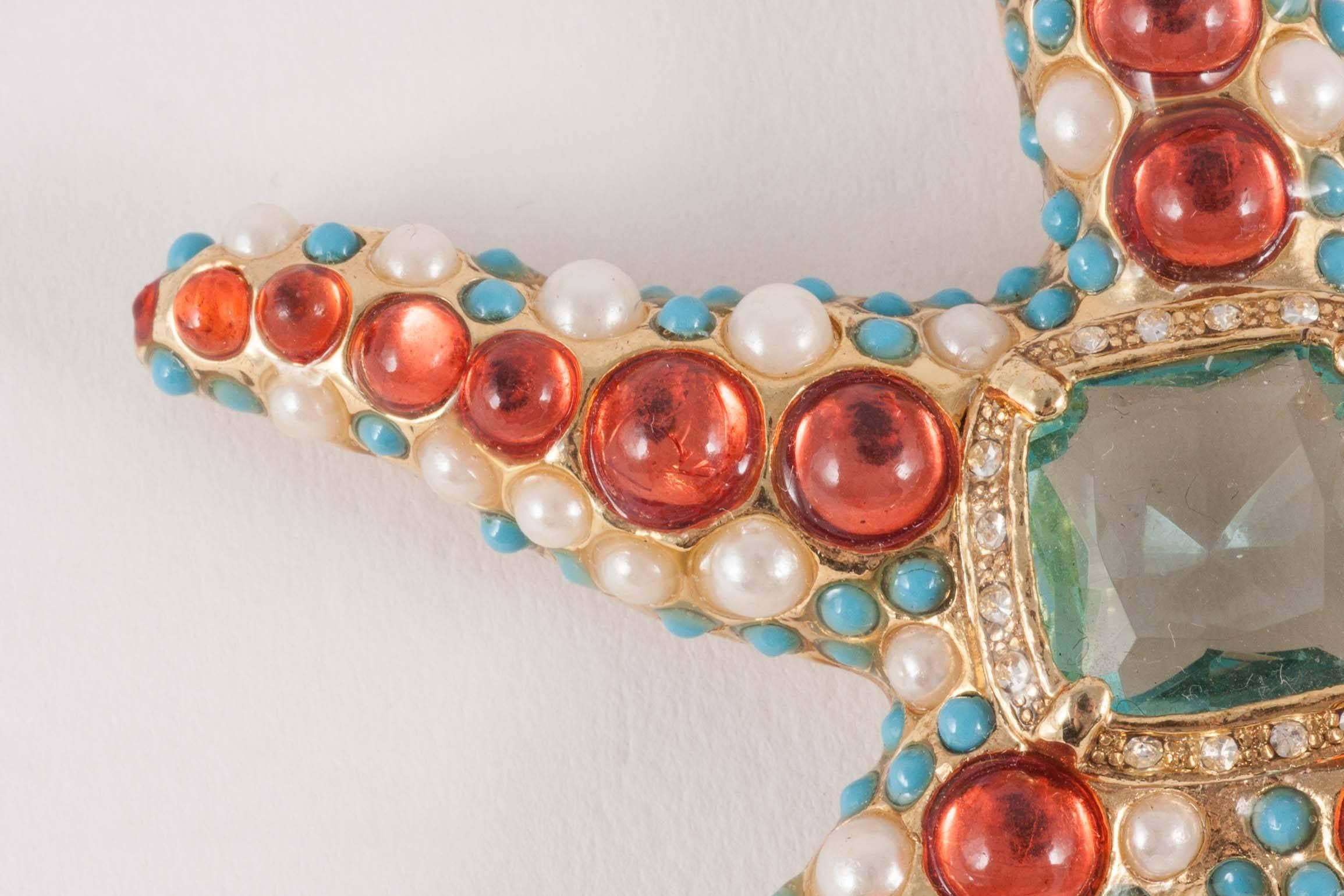 Fun and imaginative 'starfish' brooch,by Kenneth Jay Lane , from the 1960s, in a mixture of coral and turquoise cabuchons, with pearl highlights set in gilded metal. Chic and playful, this would adorn any Summer or Winter outfit, all year