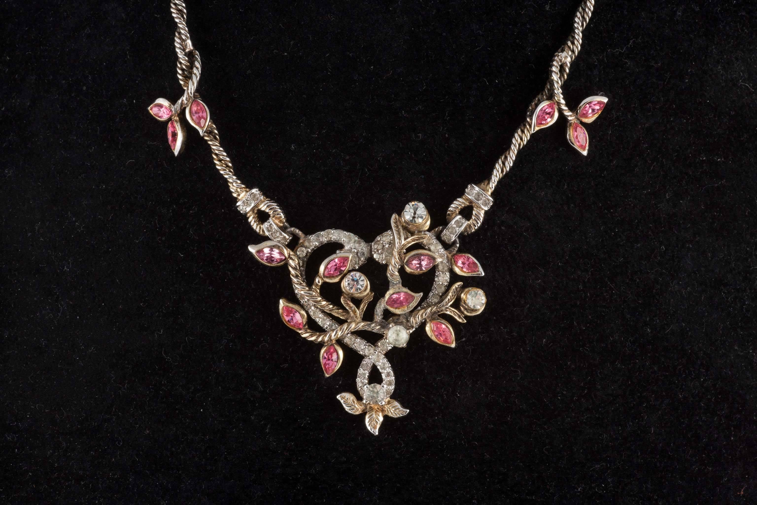 Rare and sophisticated necklace and matching earrings, in the form of a 'knotted heart' by Christian Dior, from the glorious 1950s. In soft pink and clear paste, with a twisted chain necklace, the entwined heart motif sits at the front. The matching