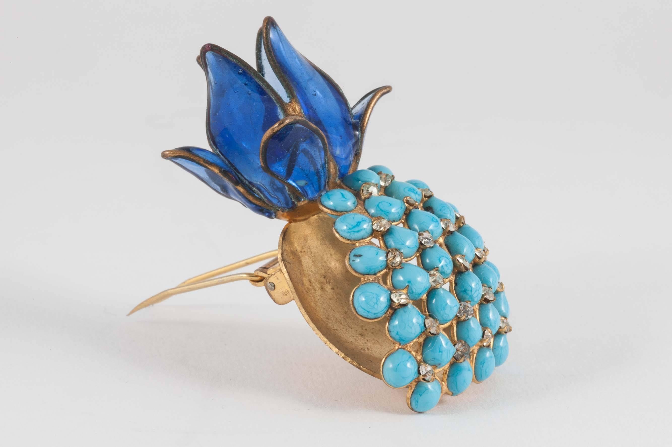Quirky and charming brooch, in the form of a 'pineapple', made by Maison Gripoix in the 1960s. Transparent poured glass form the leaves on the top, , opaque turquoise cabuchons portray the uneven surface of the pineapple itself, interspersed with
