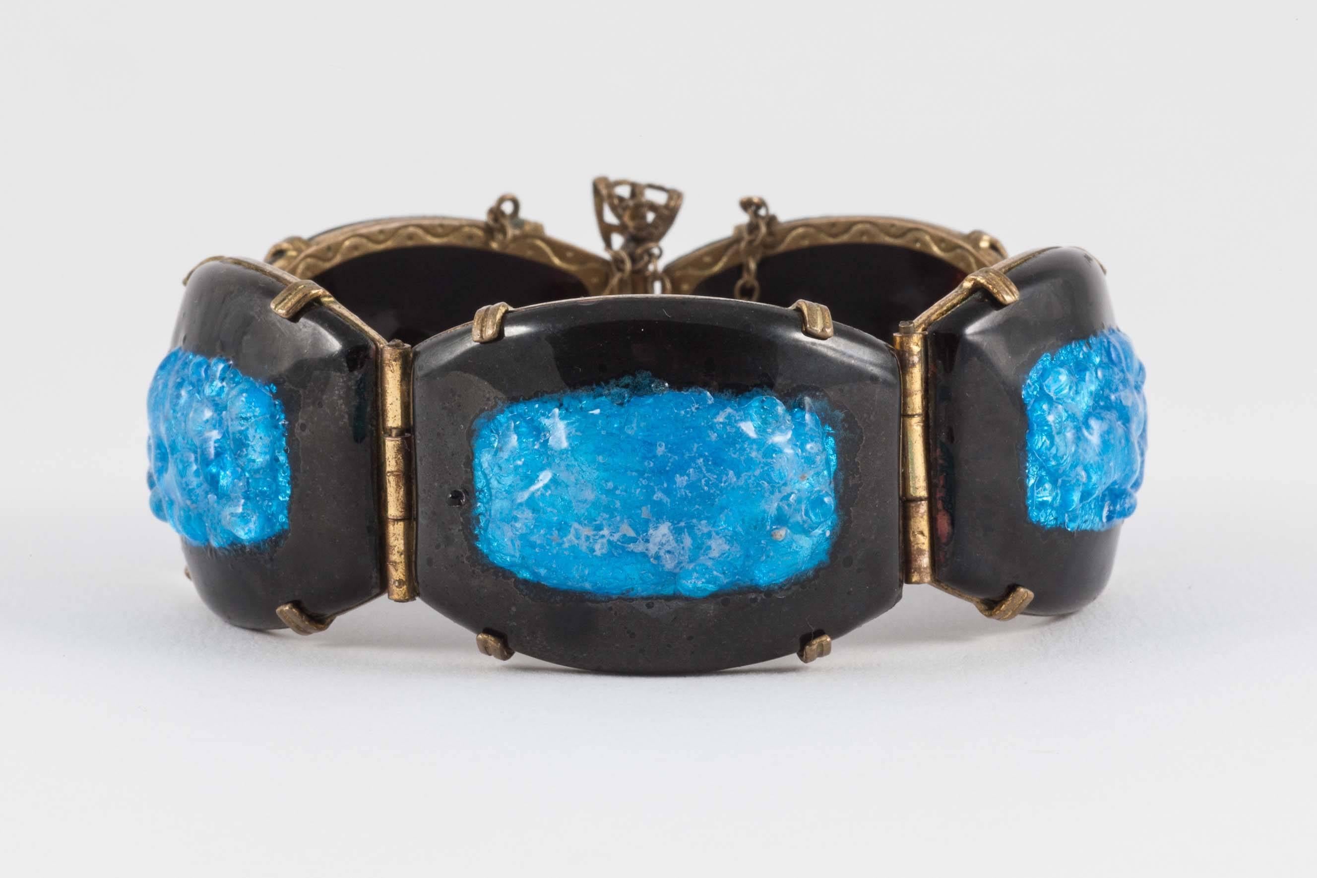 This is a lovely example of 1960s Limoges pate de verre. Enameled curved copper lozenges are hinged together with engraved brass hinged mounts.The turquoise centres have a lovely deep glow due to the technique. It sits comfortably on the wrist and